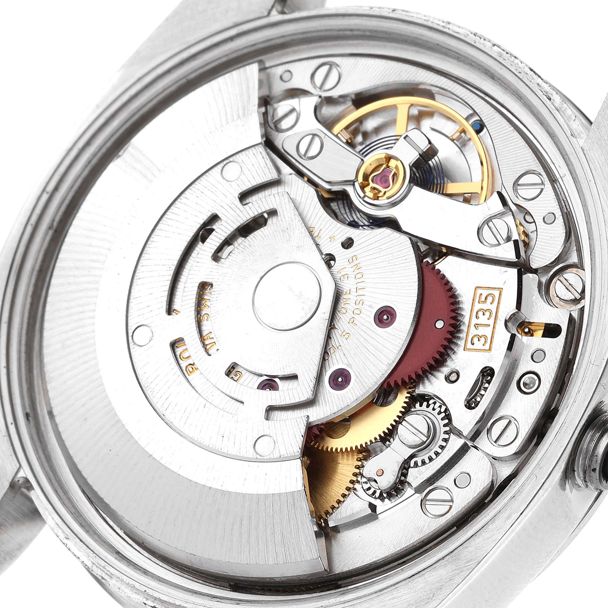 The image shows the inner mechanics of a Rolex Date 115200 Men's Stainless Steel Black Dial 115200 Men's Stainless Steel Black Dial model watch from a top-down angle, highlighting its movement parts.