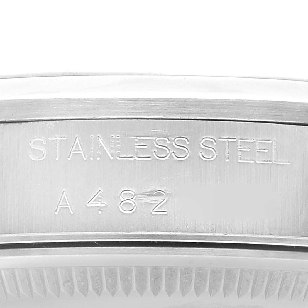 The image shows a close-up of the stainless steel case side of the Rolex Date 15200 Men's Stainless Steel Pink Dial 15200 Men's Stainless Steel Pink Dial model watch, displaying engraved text and serial numbers.