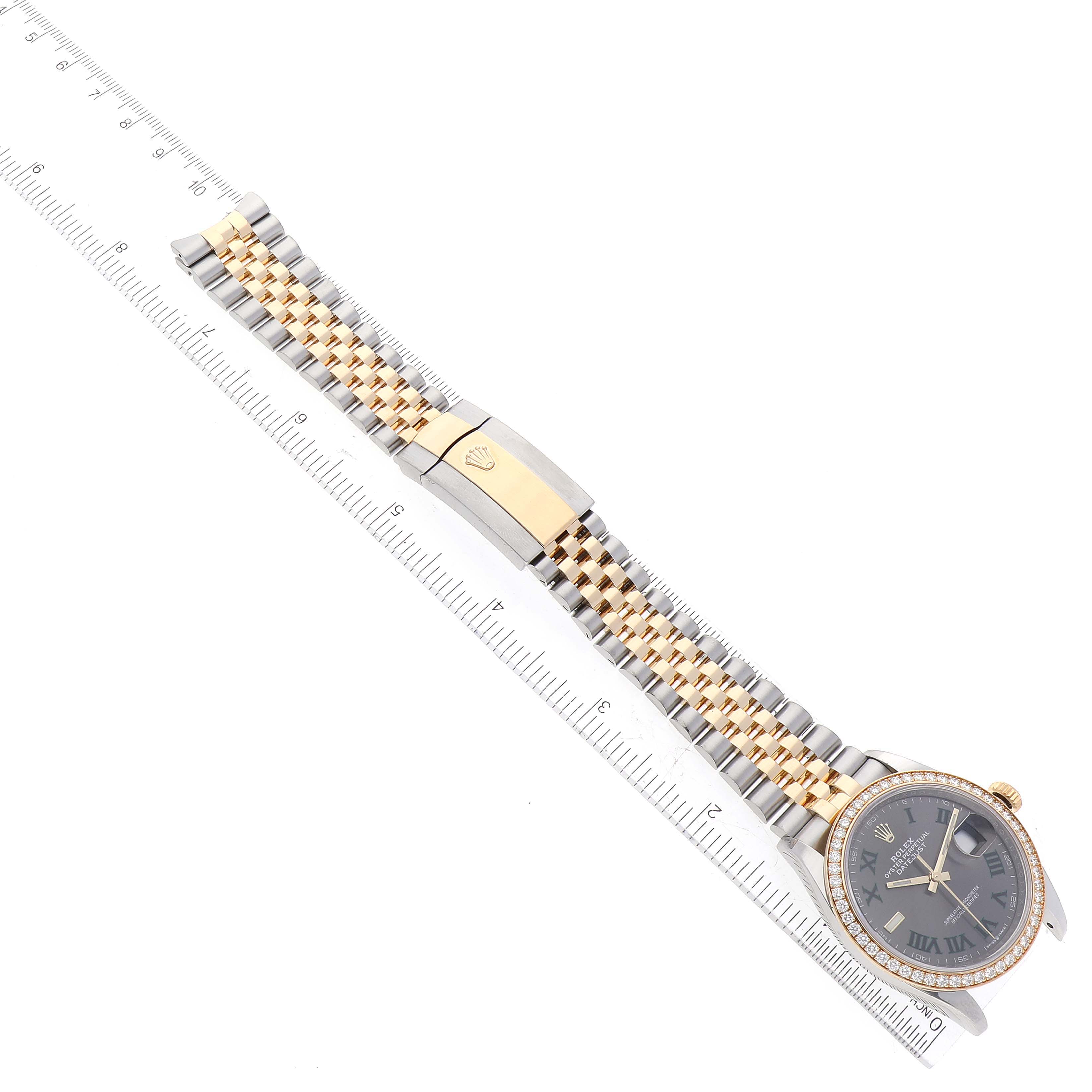 The image shows a Rolex Datejust 126283 Men's Steel and Gold (two tone) Grey Dial 126283 Men's Steel and Gold (two tone) Grey Dial watch laid flat, displaying its face, band, and clasp with a ruler for scale.