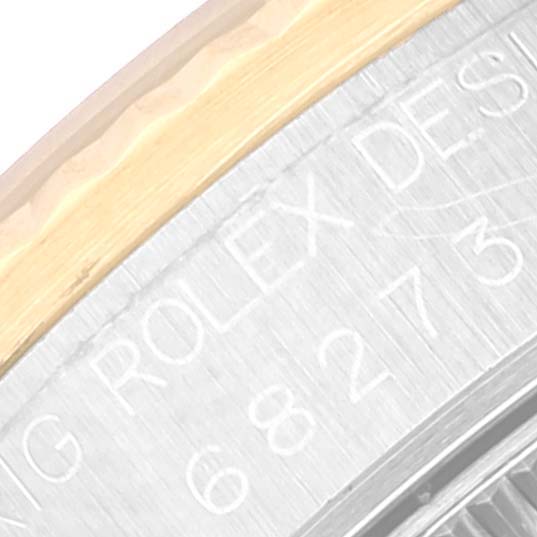 The image shows a close-up of the inner bezel and part of the case of a Rolex Mid-Size 68273 Women
s Steel and Gold (two tone) White Dial 68273 Women
s Steel and Gold (two tone) White Dial watch with "ROLEX DESIGN" inscribed.
