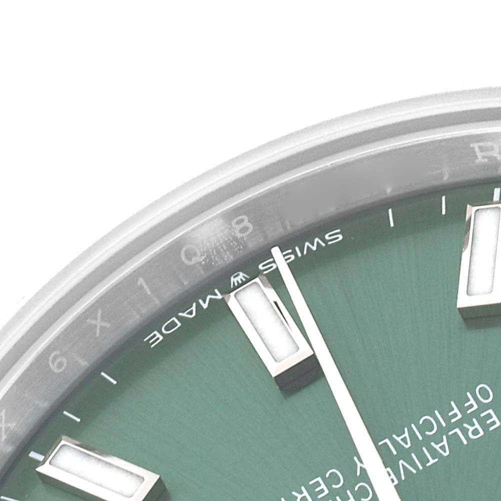 The image shows a partial close-up of the dial and hour markers on a Mid-Size Rolex watch, featuring words "SWISS MADE."