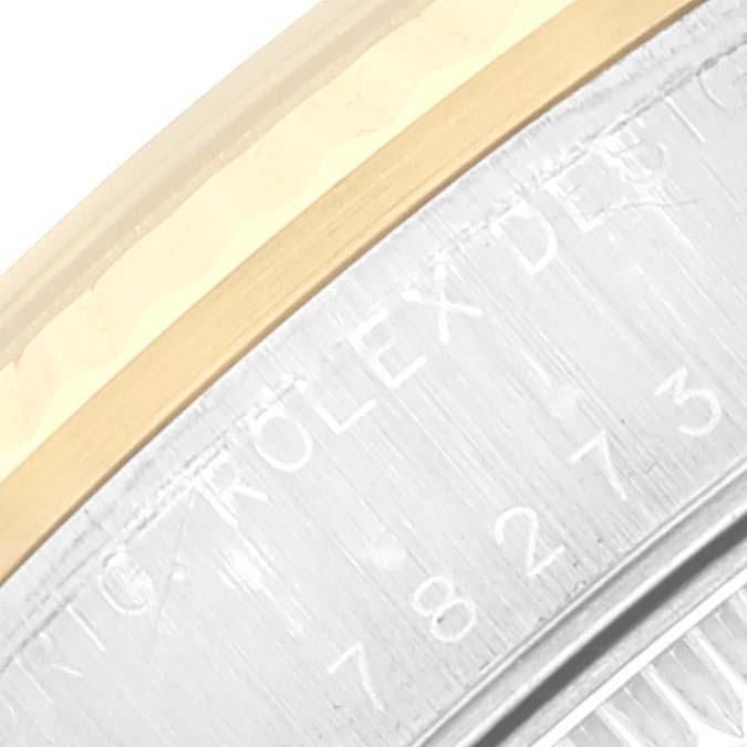 The image shows a close-up of the bezel and the casing of a Mid-Size Rolex watch, highlighting the engraving details.