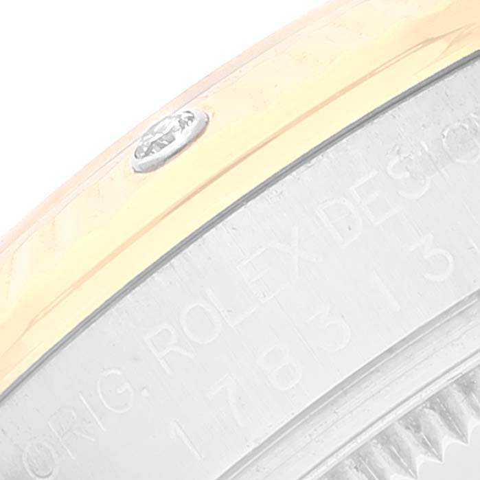 The image shows a close-up of a Mid-Size Rolex watch, displaying part of the bezel and the engraved model details.