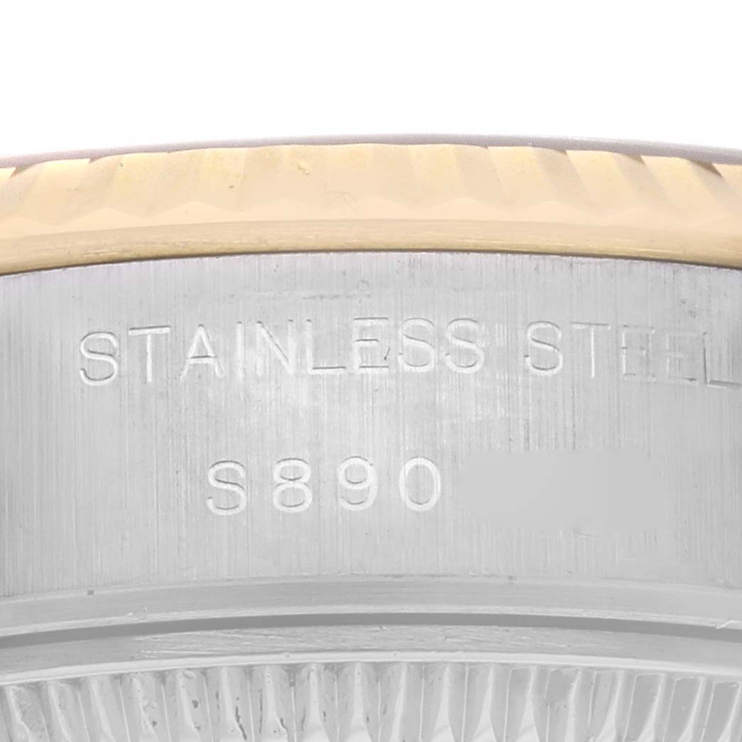 The image shows a close-up of the side of a Rolex Datejust 69173 Women
s Steel and Gold (two tone) Champagne Dial 69173 Women
s Steel and Gold (two tone) Champagne Dial, highlighting the stainless steel and engravings.