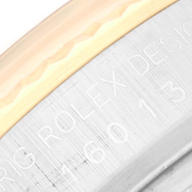 This close-up image shows the engraved writing on the side of the bezel and case of a Rolex Datejust 16013 Men's Steel and Gold (two tone) Silver Dial 16013 Men's Steel and Gold (two tone) Silver Dial watch.