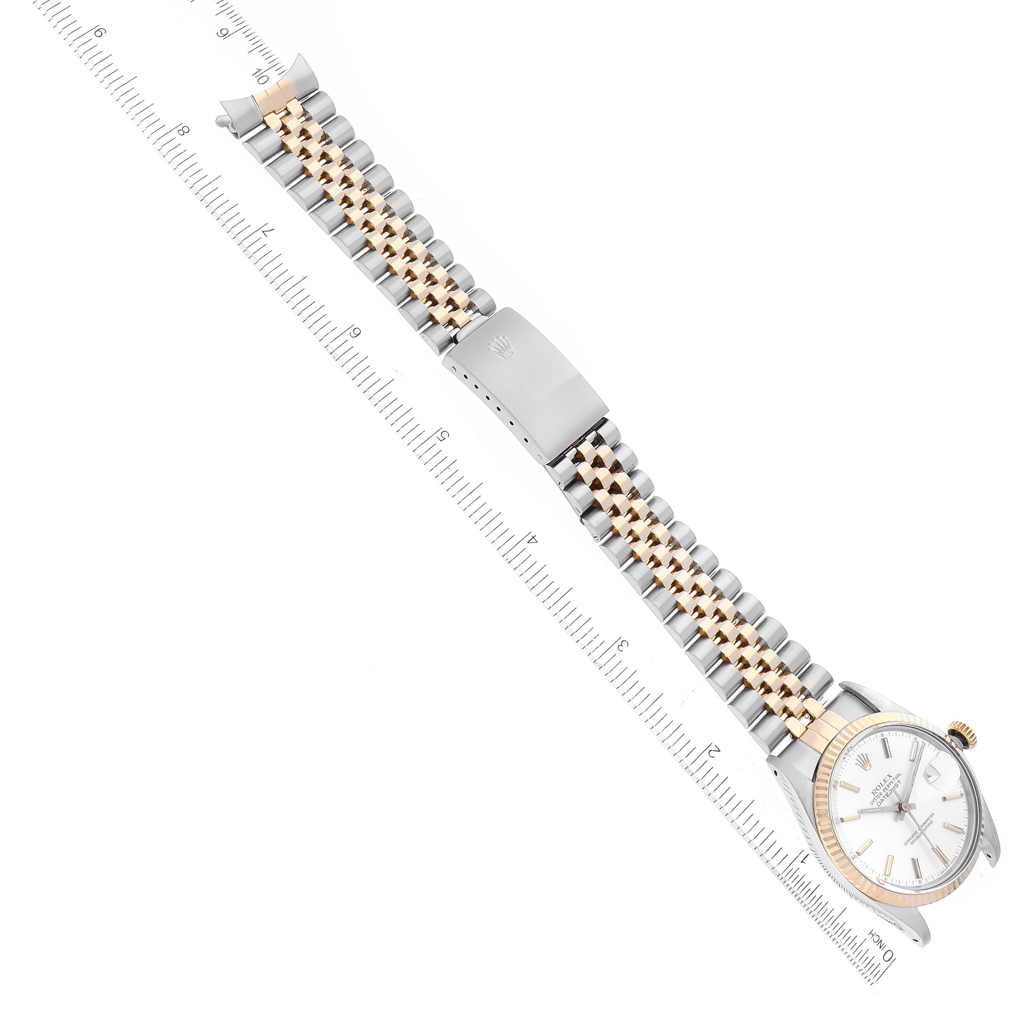 The image shows a Rolex Datejust 16013 Men's Steel and Gold (two tone) Silver Dial 16013 Men's Steel and Gold (two tone) Silver Dial watch laid flat from a top-down angle, displaying the face, bezel, and bracelet alongside a ruler.