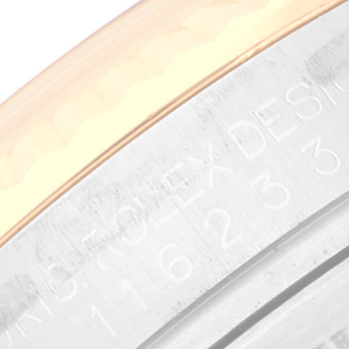 The image shows a close-up of the side of a Rolex Datejust 116233 Men's Steel and Gold (two tone) White Dial 116233 Men's Steel and Gold (two tone) White Dial watch, highlighting the serial number engraving on the metal.