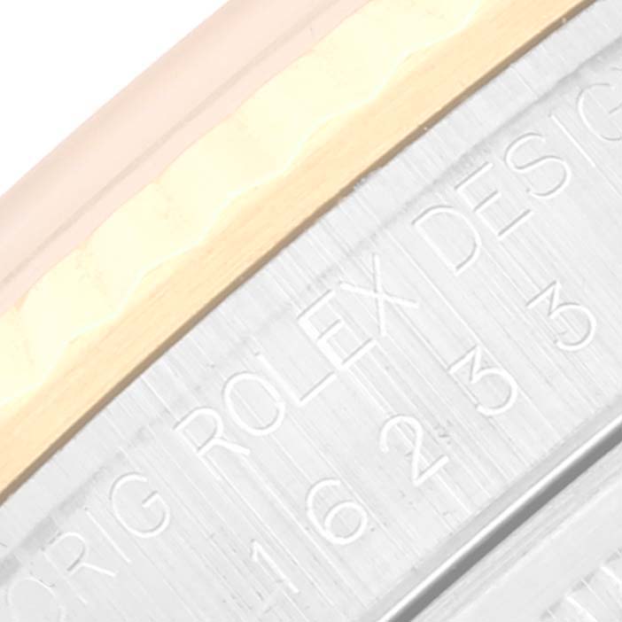 The image shows an angled view of the Rolex Datejust 16233 Men's Steel and Gold (two tone) White Dial 16233 Men's Steel and Gold (two tone) White Dial watch's side, featuring part of the bezel and engraved text.