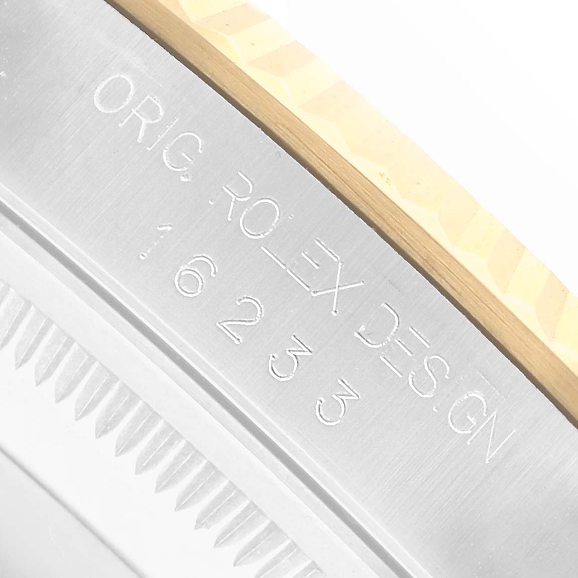 The image shows a close-up of the side of a Rolex Datejust 16233 Men
s Steel and Gold (two tone) Champagne Dial watch, highlighting the engraved details on the bezel and case.