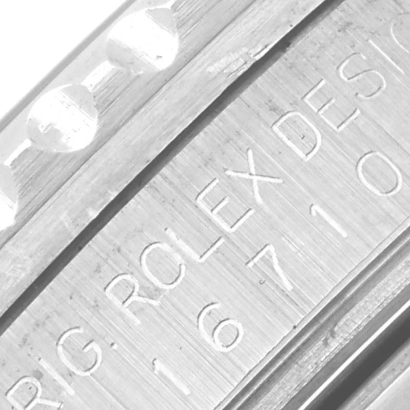The image shows a close-up of the engraved serial number area on a Rolex GMT-Master 16710 Men
s Stainless Steel Black Dial 16710 Men
s Stainless Steel Black Dial watch case.
