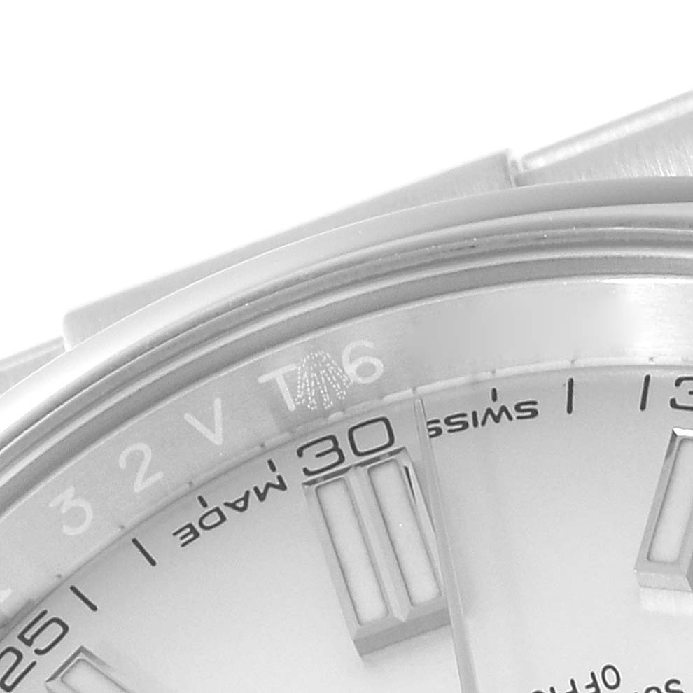 The image shows a close-up of the watch face and bezel of a Rolex Oyster Perpetual 116000 Men's Stainless Steel White Dial 116000 Men's Stainless Steel White Dial model, focusing on the 12 o'clock and 30-minute markers.
