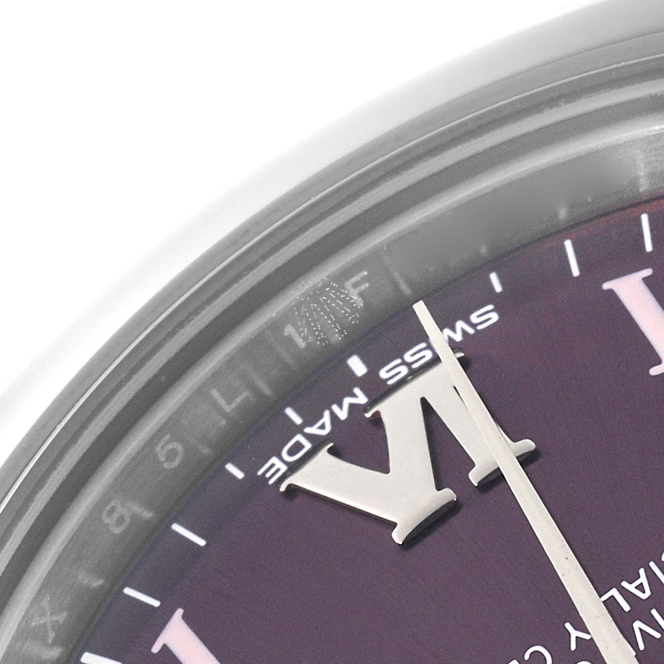 The image shows a close-up of the dial and part of the bezel of the Mid-Size Rolex watch, focusing on the VI hour marker and "Swiss Made" text.