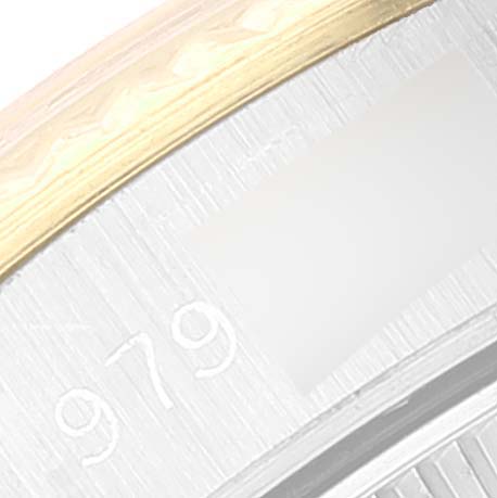 This image shows a close-up of the case and bezel of a Rolex Oyster Perpetual 67193 Women
s Steel and Gold (two tone) White Dial 67193 Women
s Steel and Gold (two tone) White Dial watch, highlighting part of the serial number and gold detailing.