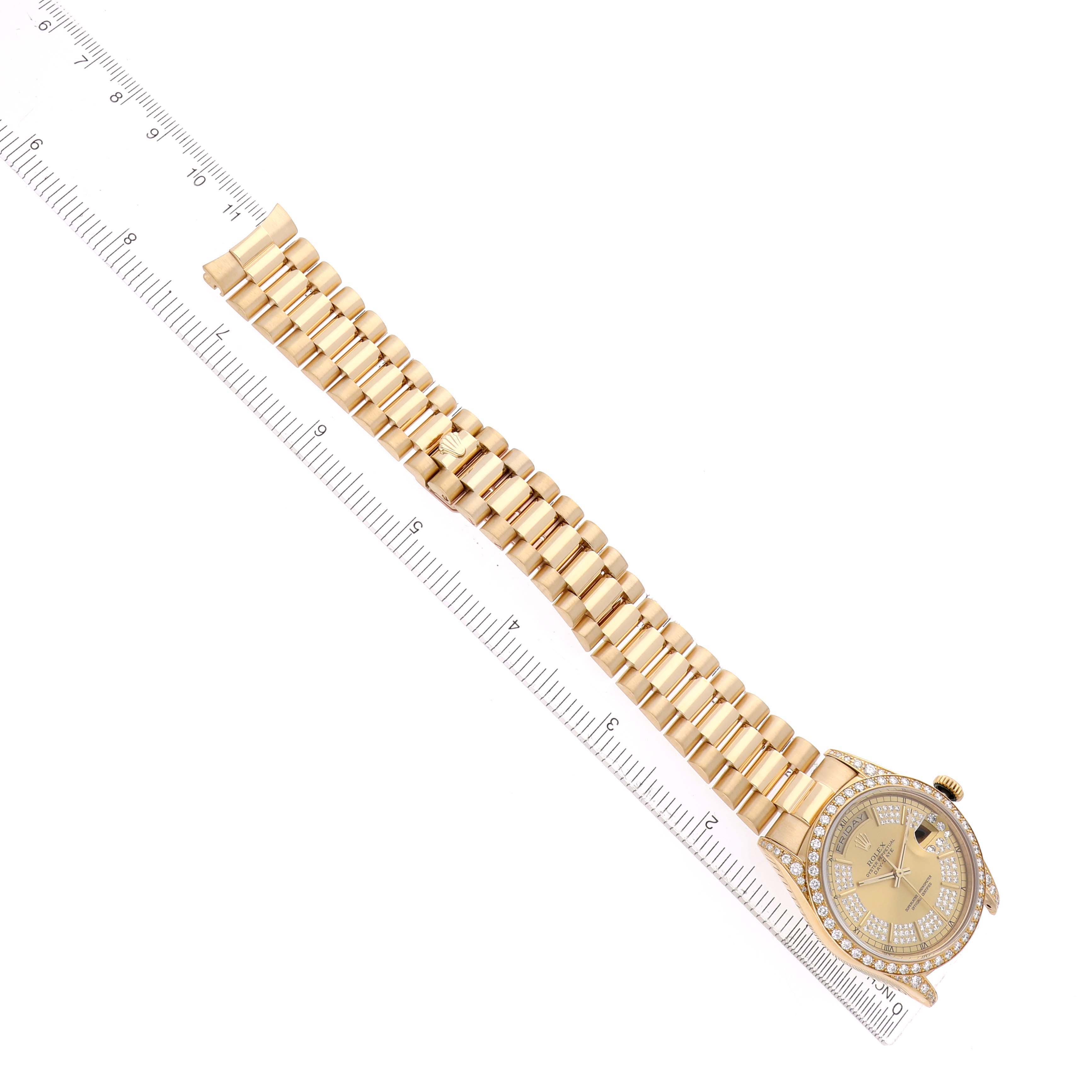 The Rolex President 18388 Men
s Yellow Gold Champagne Dial watch is shown from a top-down angle, highlighting its bracelet, case, and dial next to a ruler.