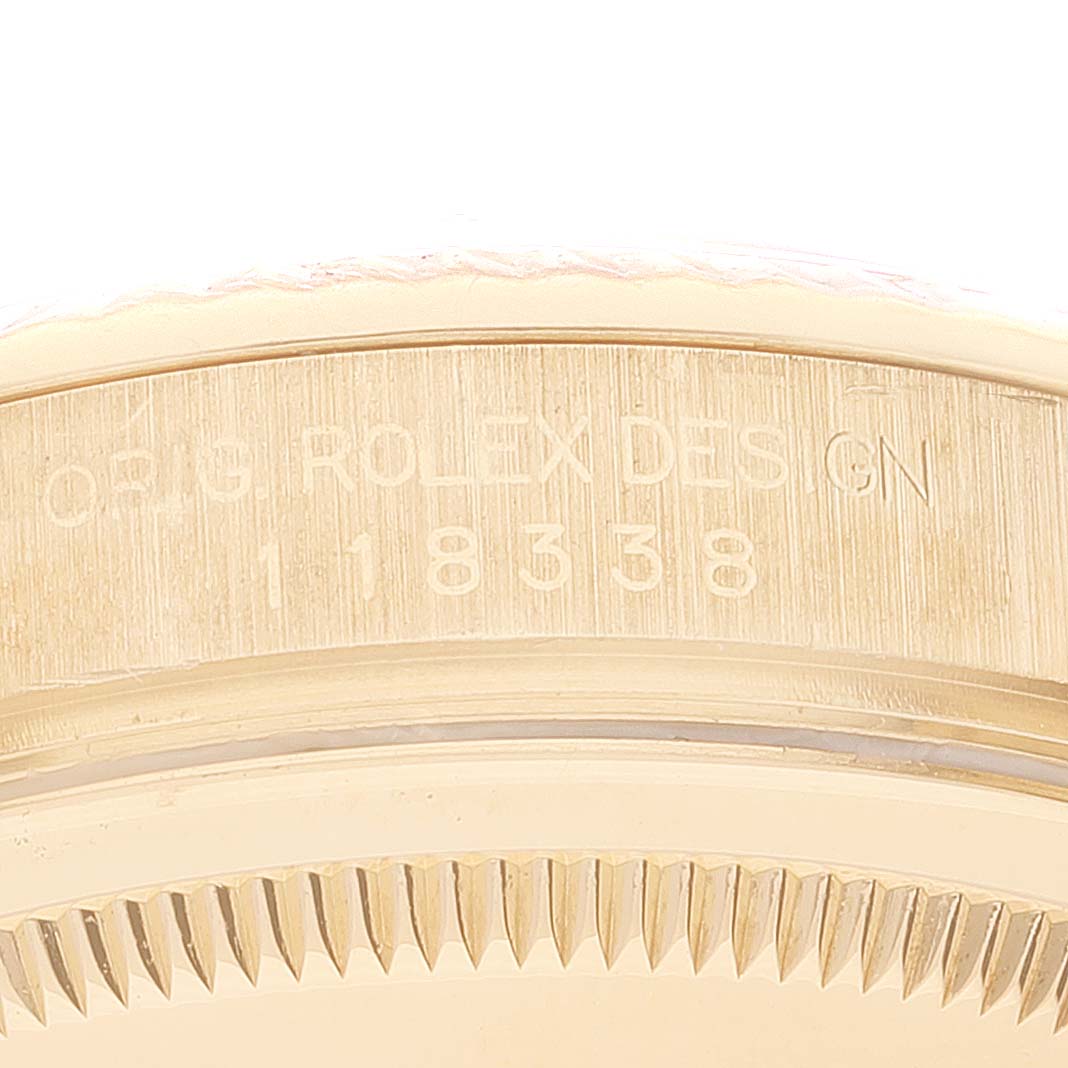 Close-up of the bezel and case back of a Rolex President 118338 Men's Yellow Gold  118338 Men's Yellow Gold  model with visible engravings and fluted design.