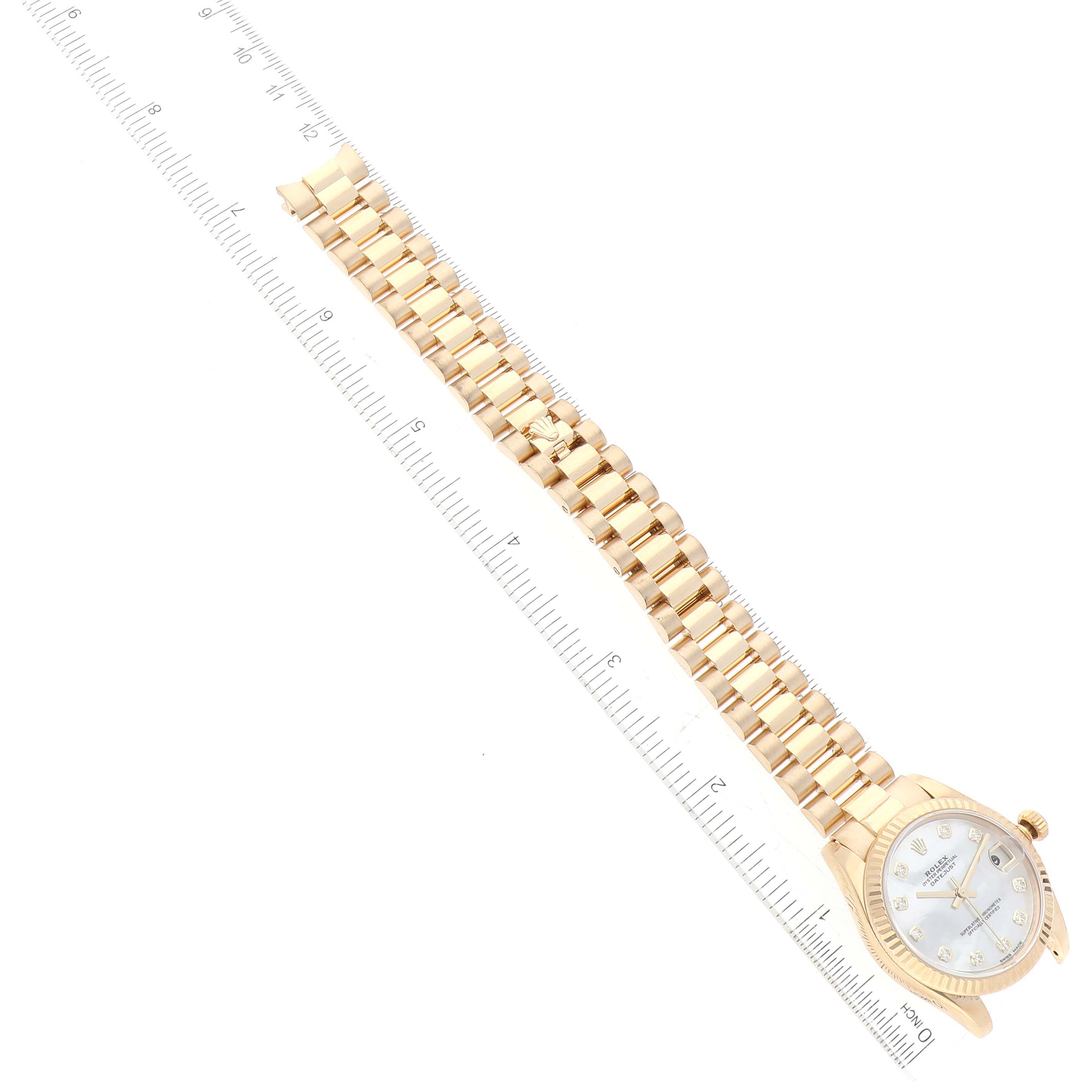The image shows a Rolex President 178278 Women's Yellow Gold Mother of Pearl Dial 178278 Women's Yellow Gold Mother of Pearl Dial model watch with its face and bracelet laid flat next to a ruler for measurement.