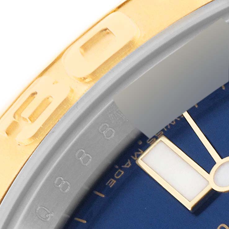 This close-up image of the Rolex Yacht-Master 16623 Men
s Steel and Gold (two tone) Blue Dial 16623 Men
s Steel and Gold (two tone) Blue Dial watch shows a portion of the bezel, dial, and a watch hand.