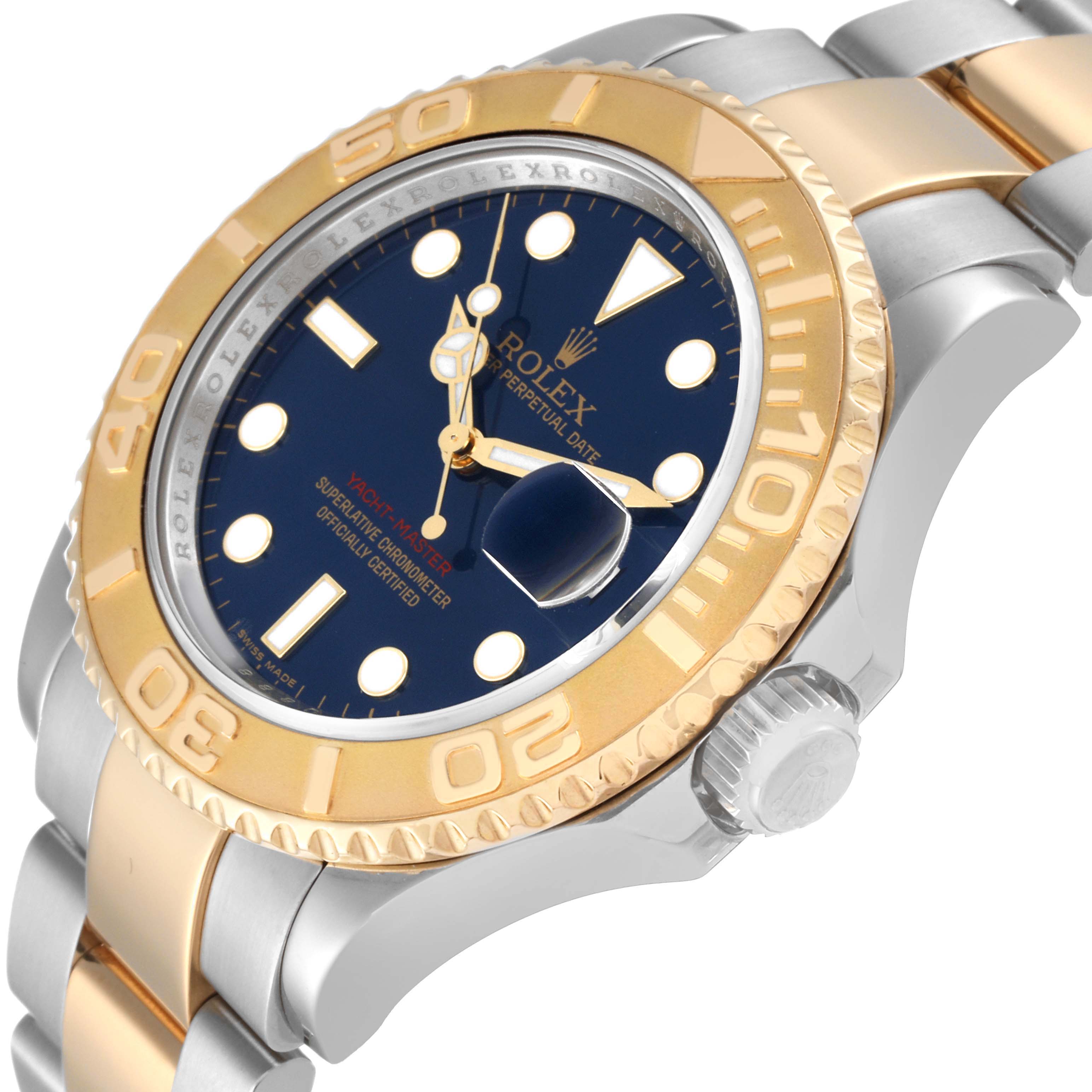 This image shows a close-up view of the Rolex Yacht-Master 16623 Men
s Steel and Gold (two tone) Blue Dial 16623 Men
s Steel and Gold (two tone) Blue Dial watch, displaying its gold bezel, blue dial, and part of the bracelet.