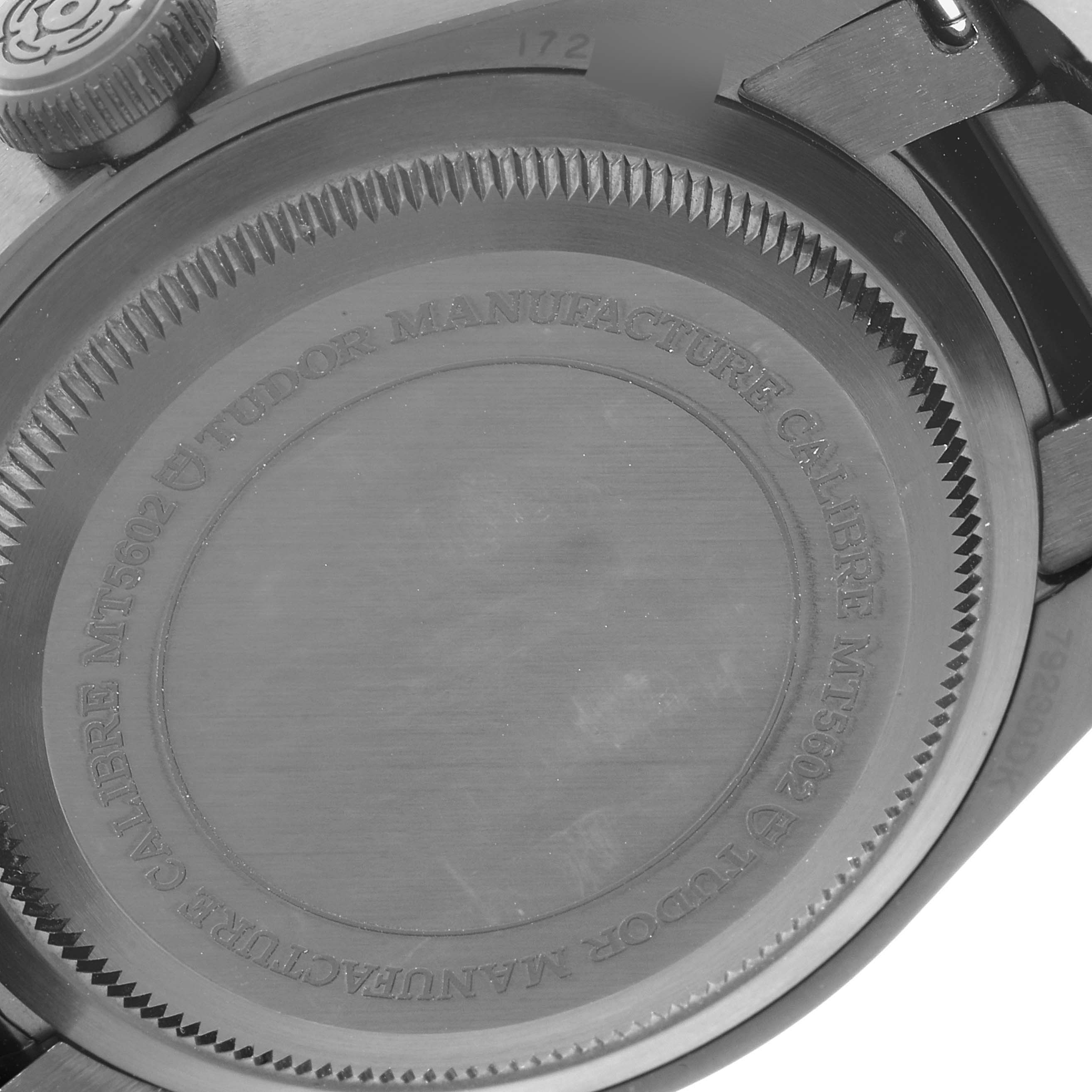 The image shows the back case of the Tudor Heritage Black Bay 79230DK Men's Stainless Steel Black Dial 79230DK Men's Stainless Steel Black Dial watch, highlighting its engraved details and crown.