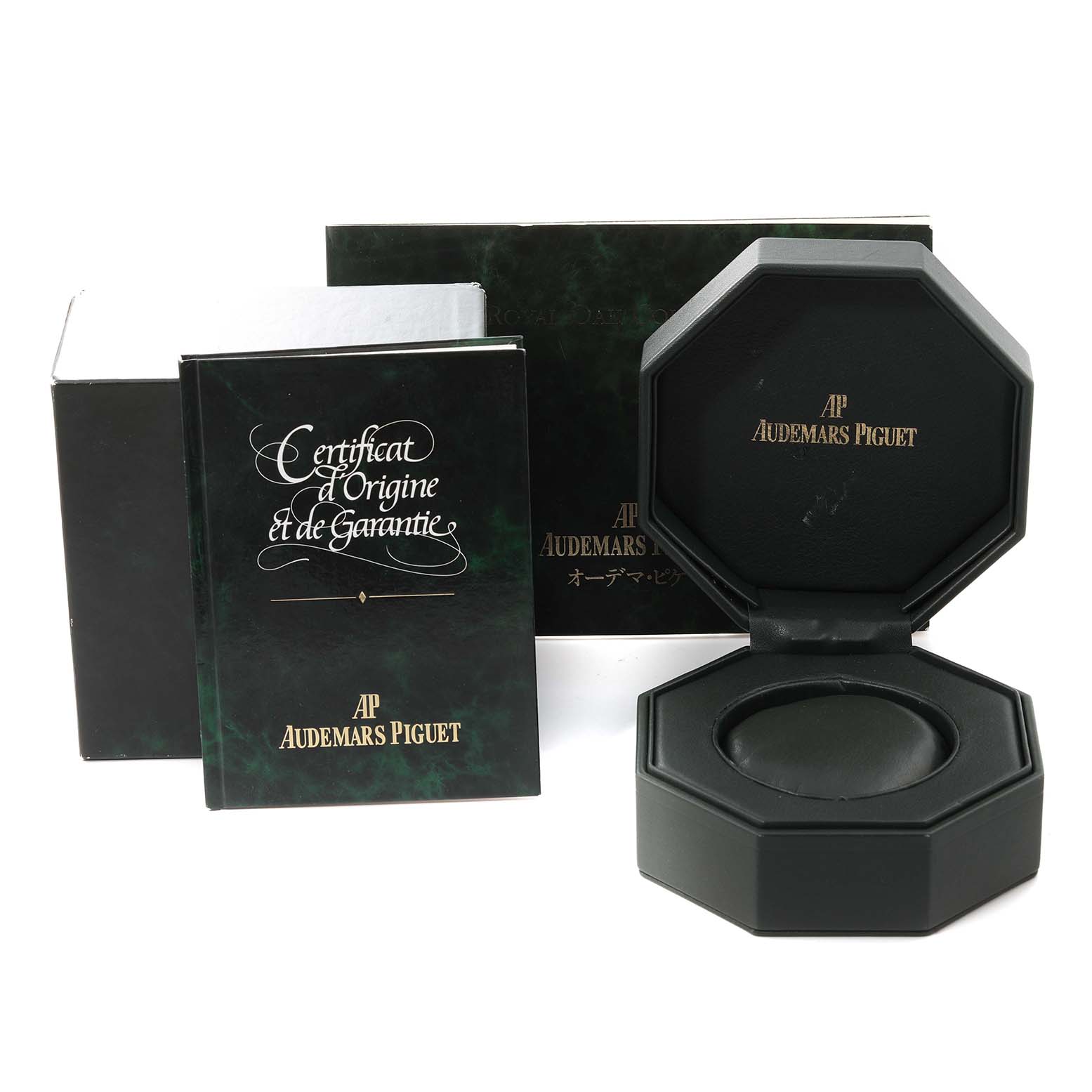 The image shows the packaging, warranty booklet, and open case for a Royal Oak watch by Audemars Piguet.