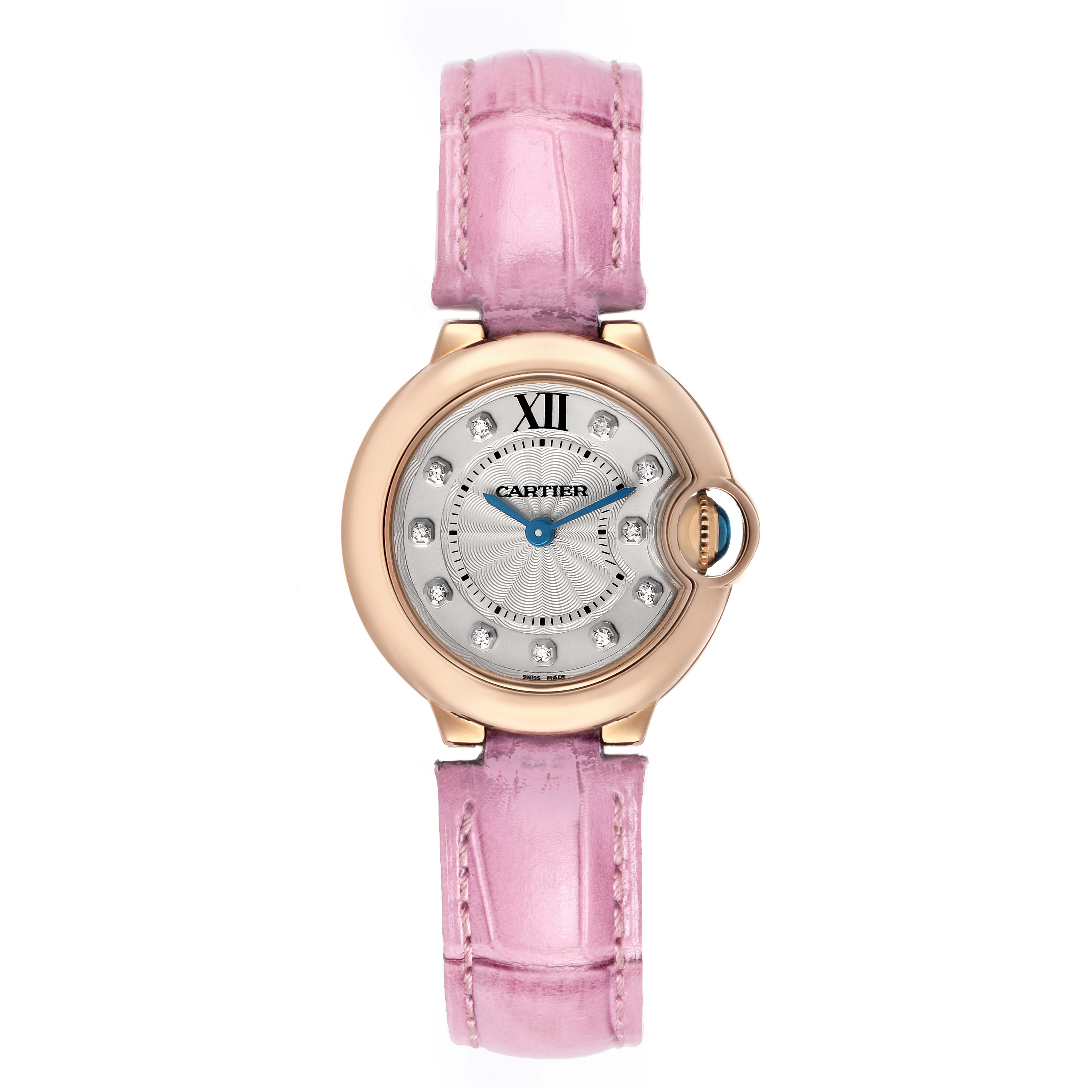 The Cartier Ballon Bleu WE902050 Women's Rose Gold Silver Dial watch is shown from a top-down angle, highlighting its pink strap, round face, and blue hands.