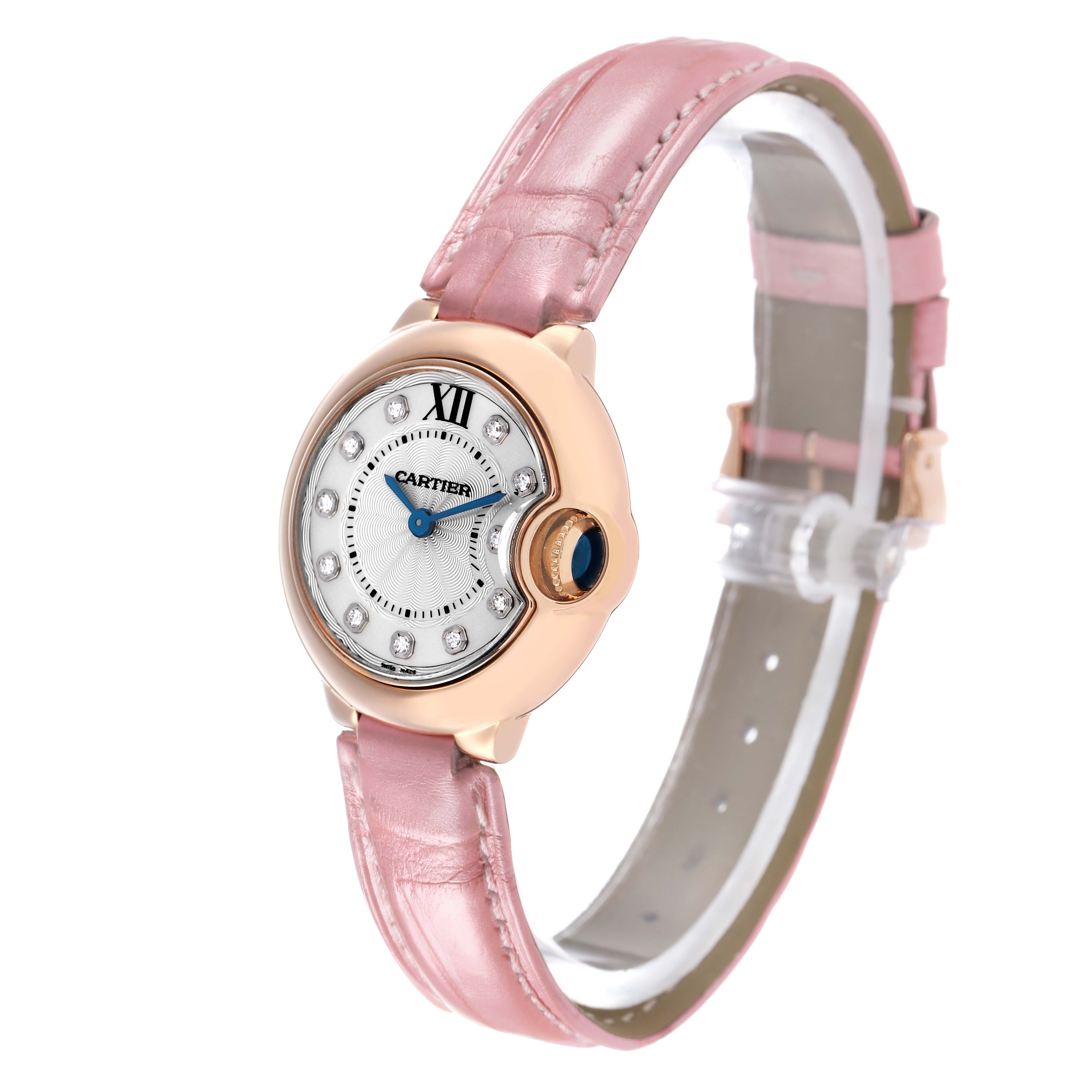 The Cartier Ballon Bleu WE902050 Women's Rose Gold Silver Dial watch is shown at an angled view, displaying the face, pink leather strap, and sapphire cabochon crown.