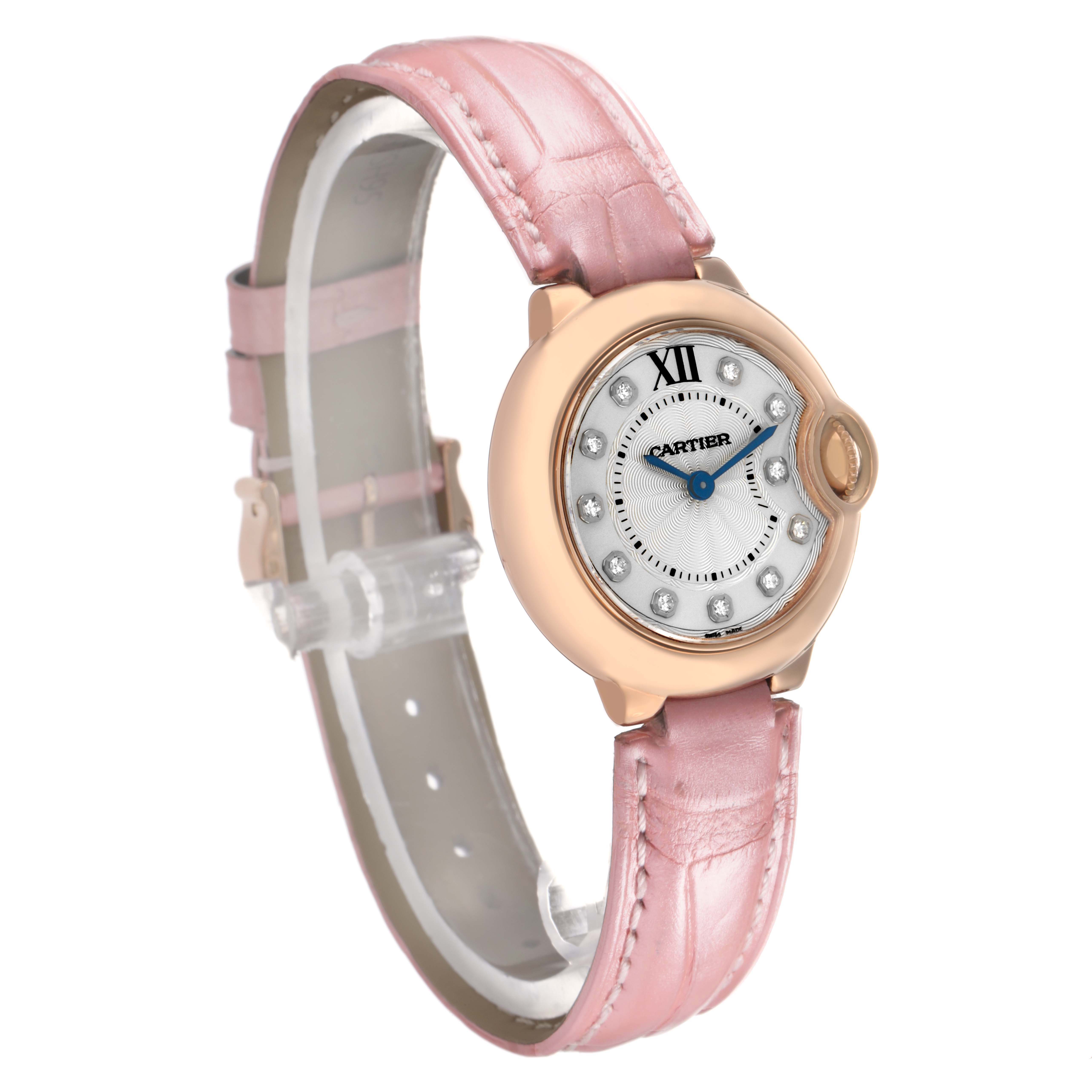 The Ballon Bleu de Cartier watch is shown at a three-quarter angle, highlighting its pink leather strap and round face.