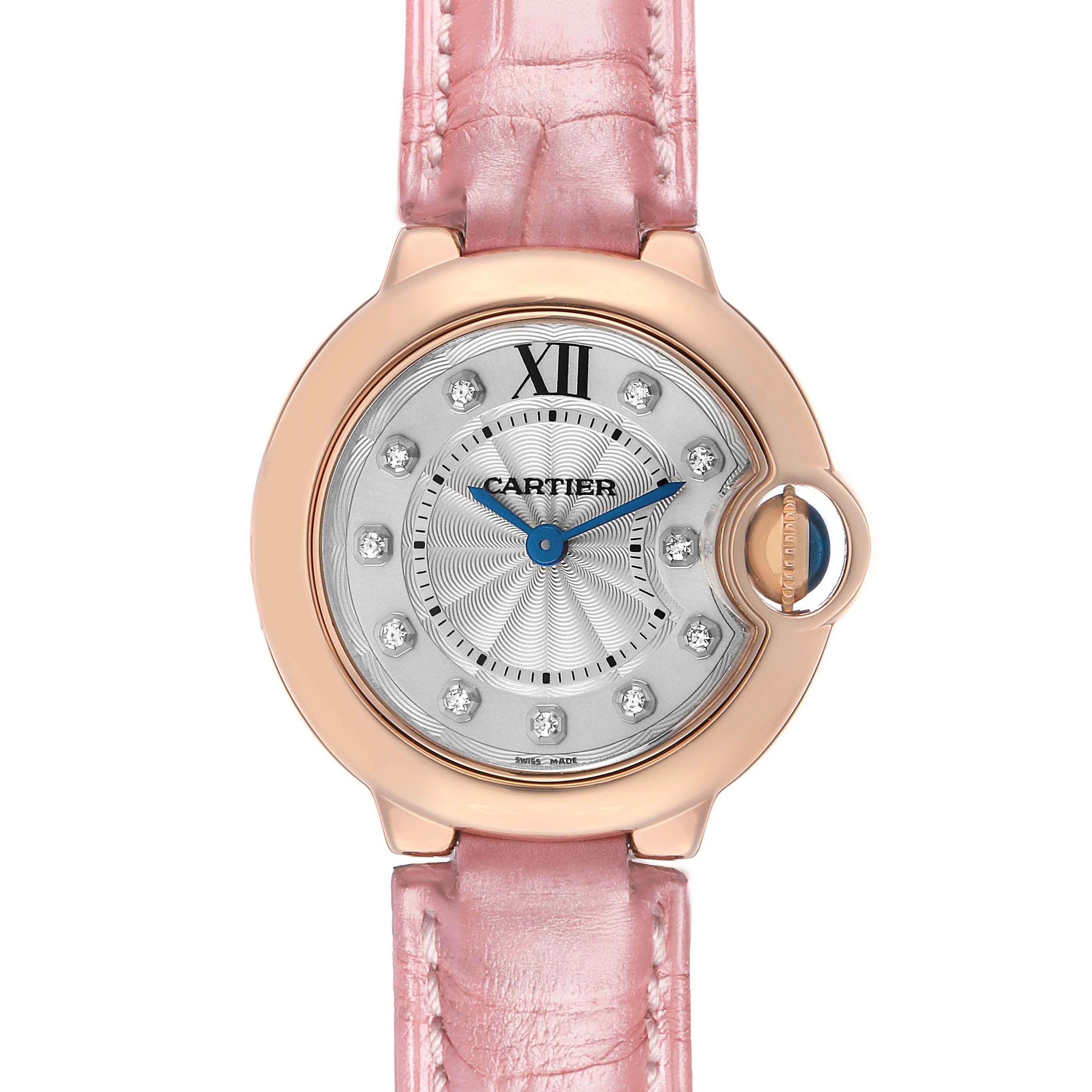 The image shows a Ballon Bleu by Cartier watch from a top-down angle, highlighting its pink strap and round face.