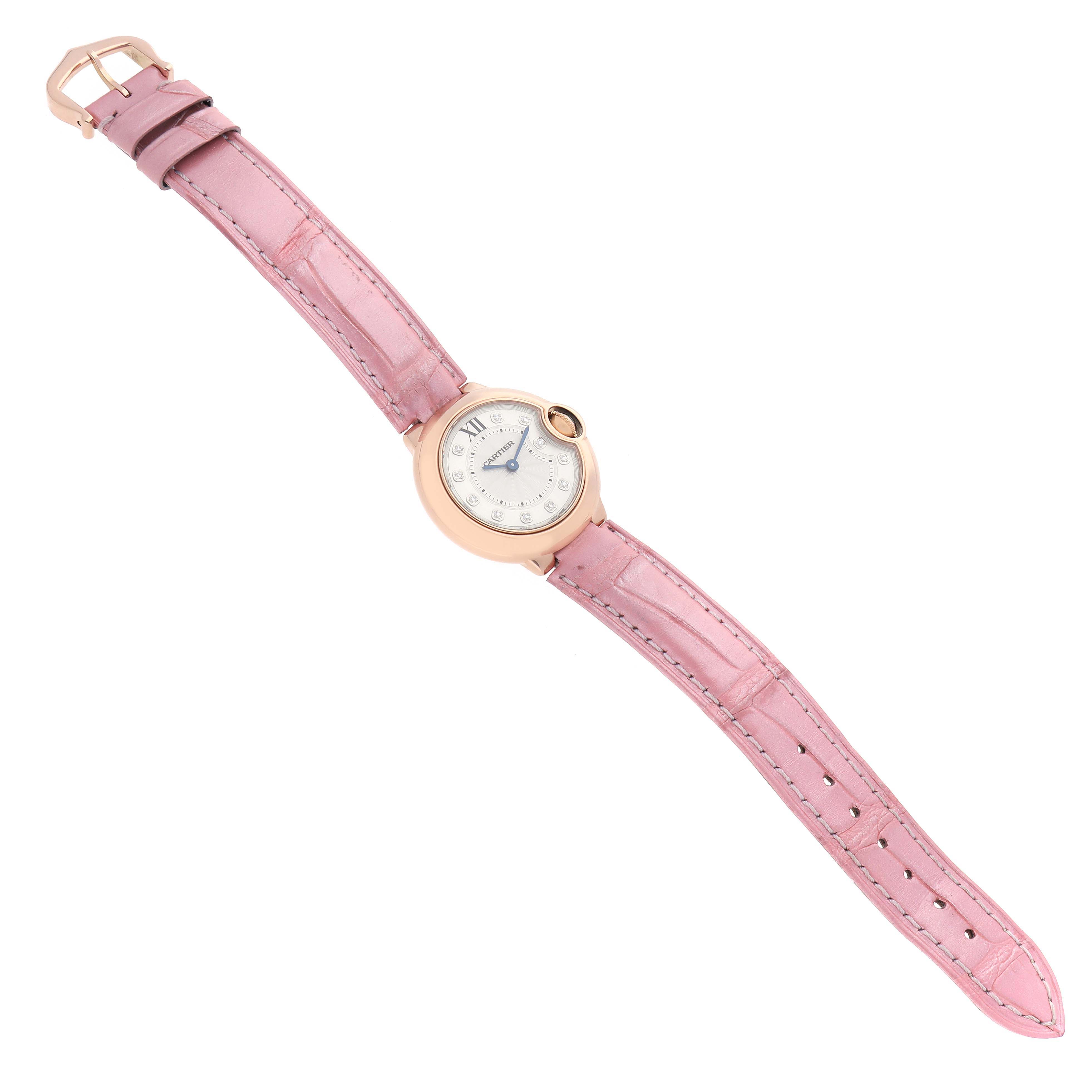 The image shows a Ballon Bleu de Cartier watch at a diagonal angle, displaying its pink leather strap and round dial.