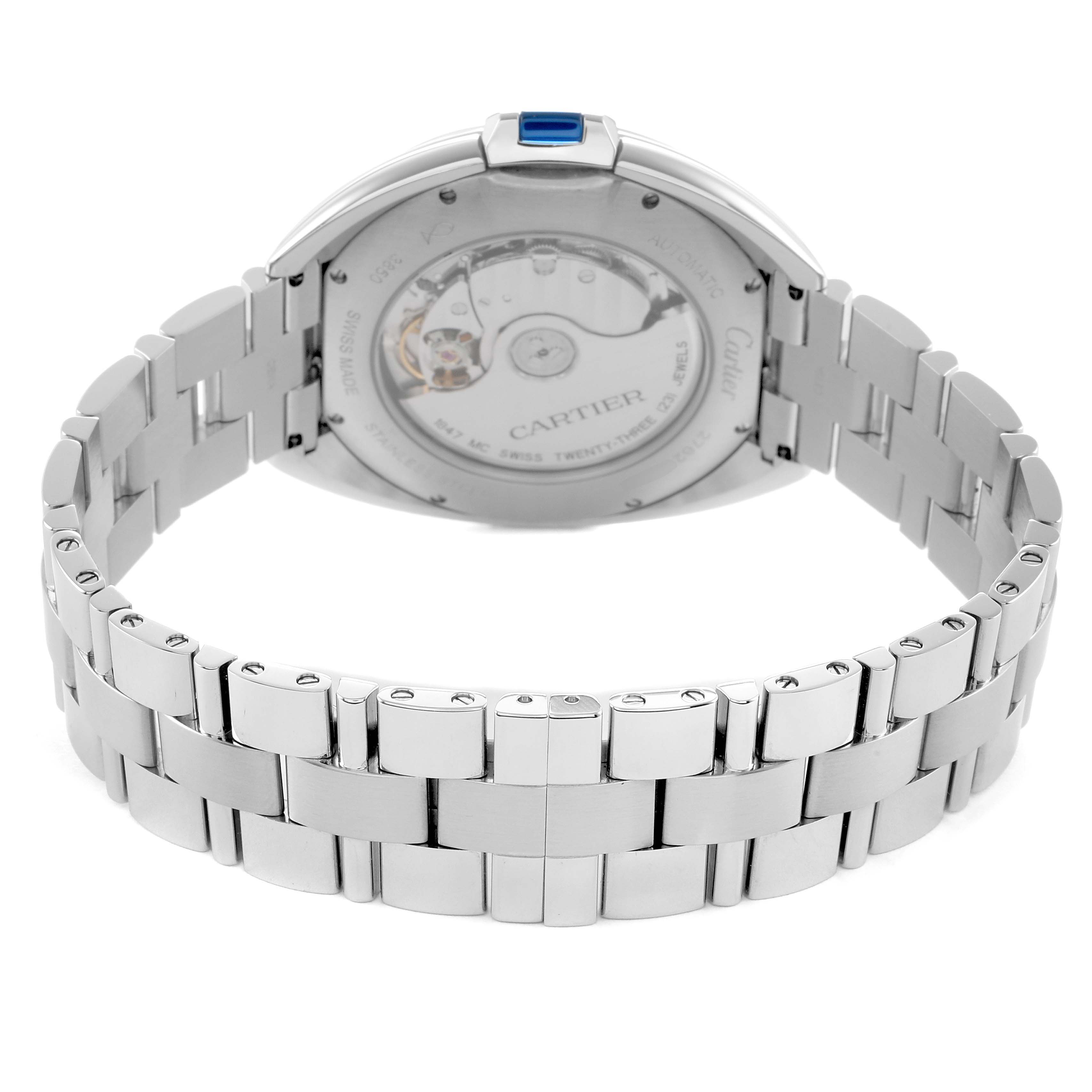 The image shows the back and bracelet of a Cartier Clé watch, highlighting the automatic movement and metal links.