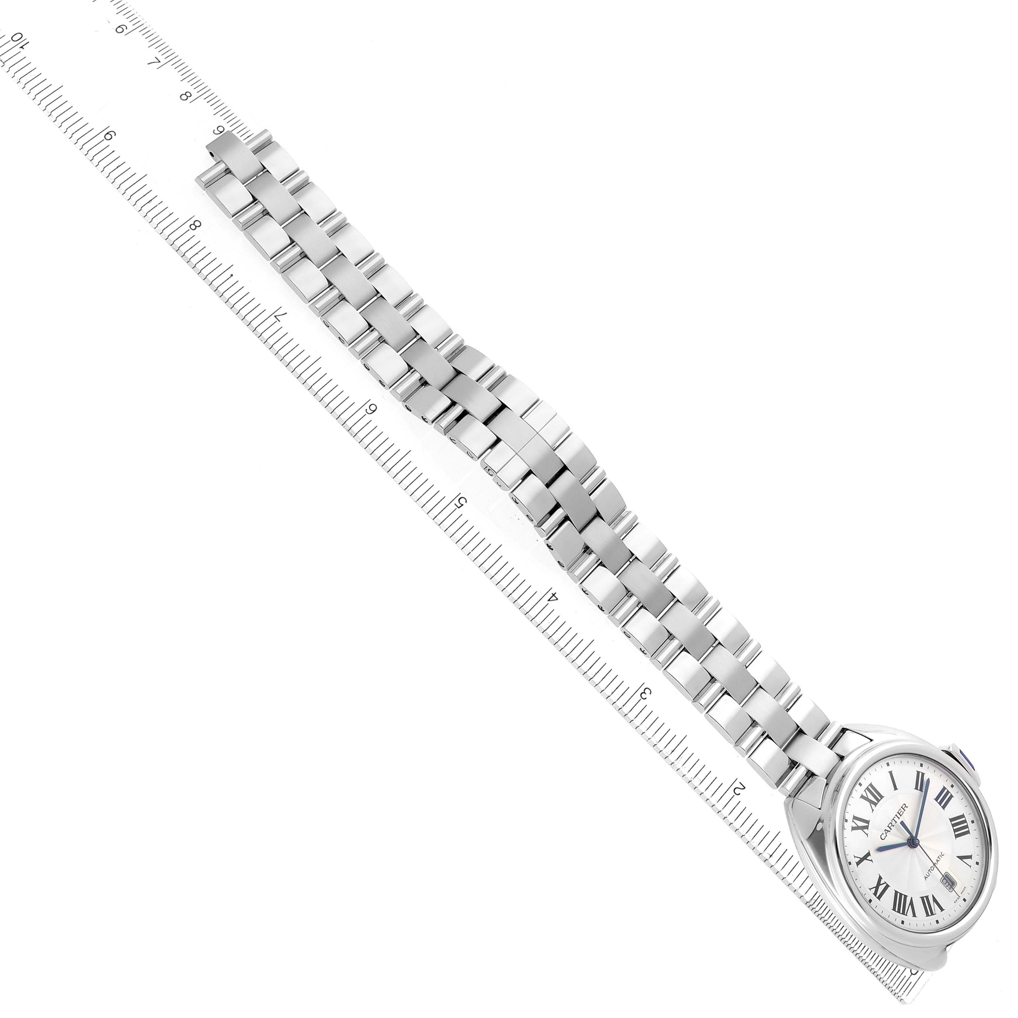 The Cartier Clé watch is shown at an angle displaying the face, bracelet, and a ruler indicating size.