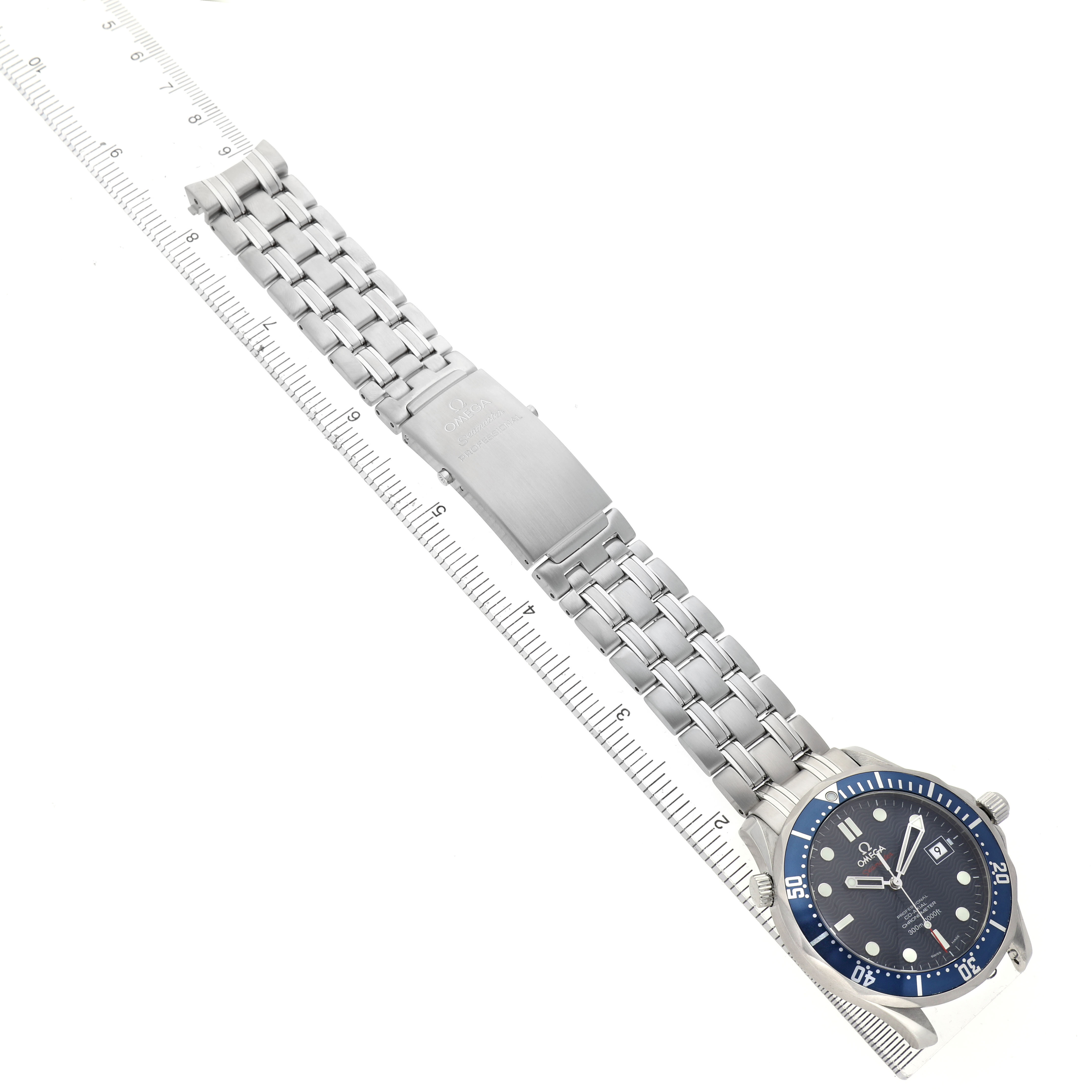 The Omega Seamaster 2220.80.00 Men's Stainless Steel Blue Dial watch is shown from a top-down angle, displaying the dial and the entire metal bracelet alongside a measuring ruler.