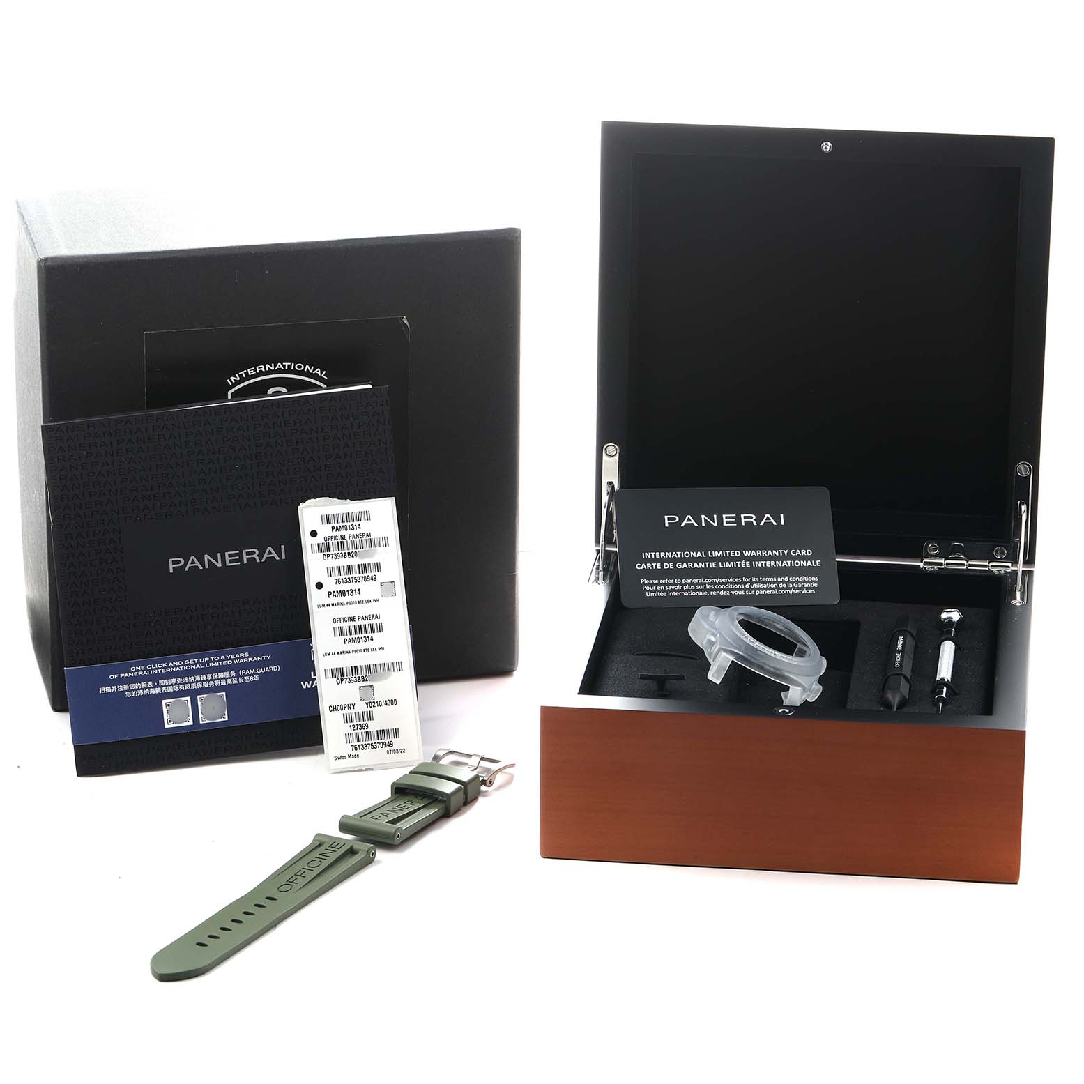 The image shows a Panerai Luminor PAM01314 Men's Stainless Steel White Dial box, manual, warranty card, green strap, and tools at an angled view.