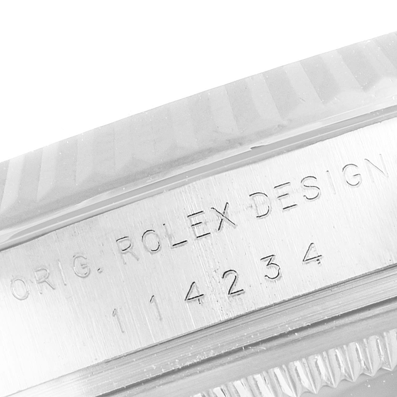 The image shows a close-up of the engraved case side of a Rolex Air-King 114234 Men's Stainless Steel Blue Dial 114234 Men's Stainless Steel Blue Dial watch, displaying its model number and "ROLEX DESIGN."