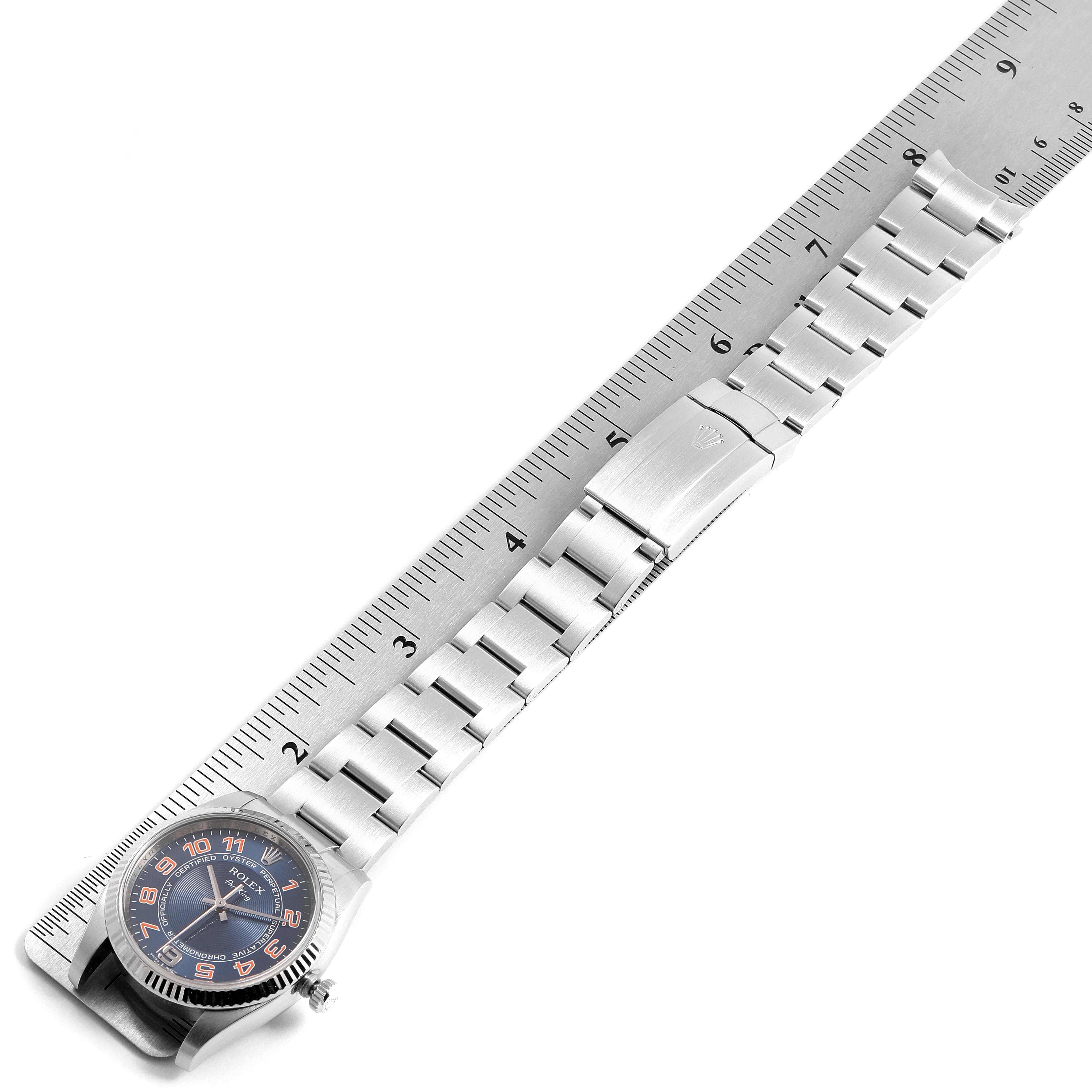 The image shows the Rolex Air-King 114234 Men's Stainless Steel Blue Dial 114234 Men's Stainless Steel Blue Dial watch from an overhead angle, displaying the face, crown, and full bracelet against a ruler for scale.