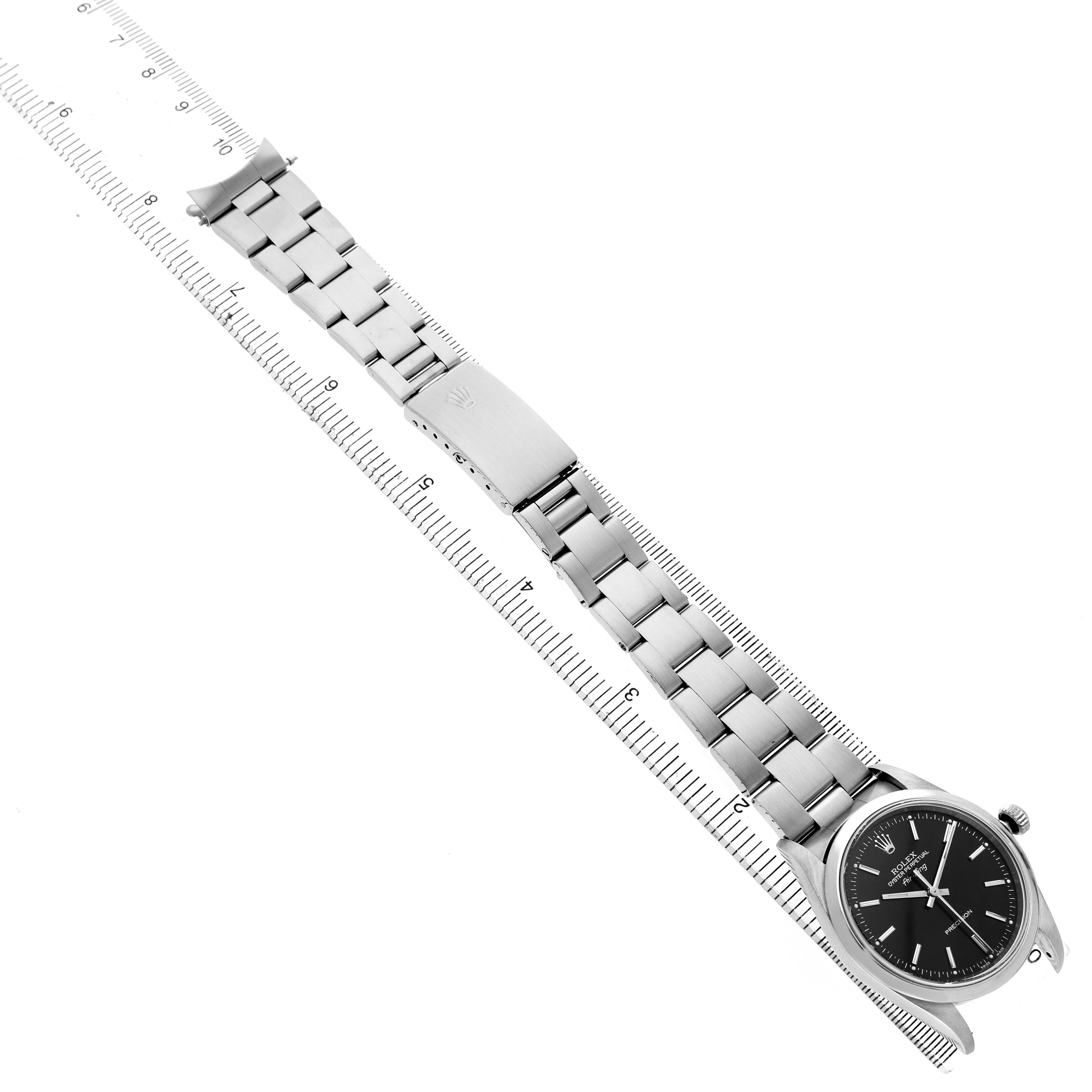 The Rolex Air-King 14000 Men's Stainless Steel Black Dial watch is shown from an angled top-down view, with the face, bracelet, and clasp visible alongside a ruler.