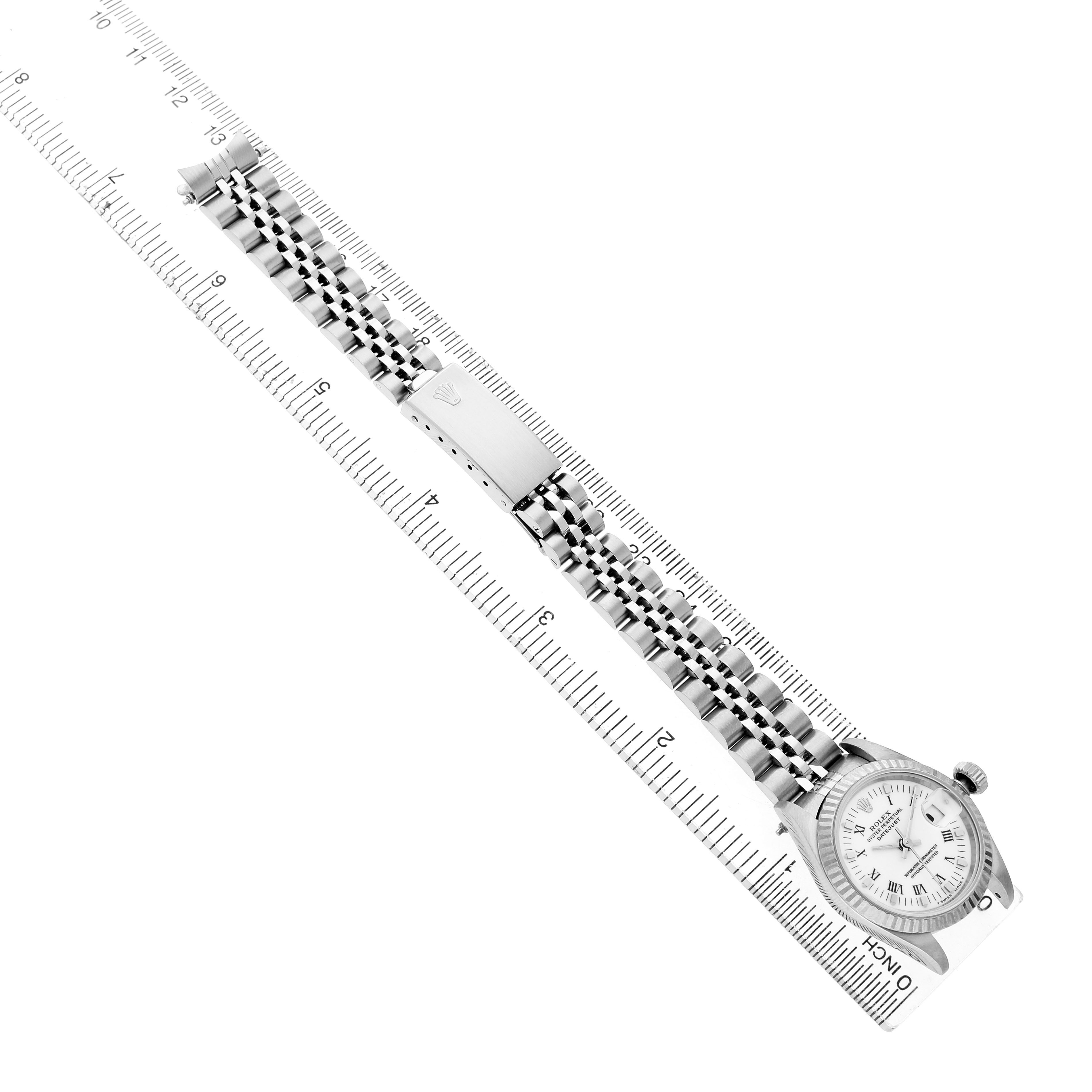 The watch is a Rolex Datejust 69174 Women's Stainless Steel White Dial, shown diagonally with the full bracelet extended alongside a ruler.