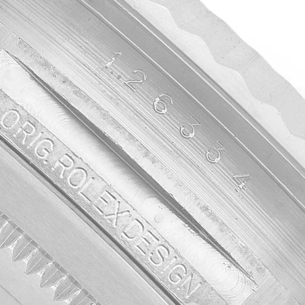 The image shows a close-up of engravings on the inner bezel of a Rolex Datejust 41 126334 Men's Stainless Steel Grey Dial.