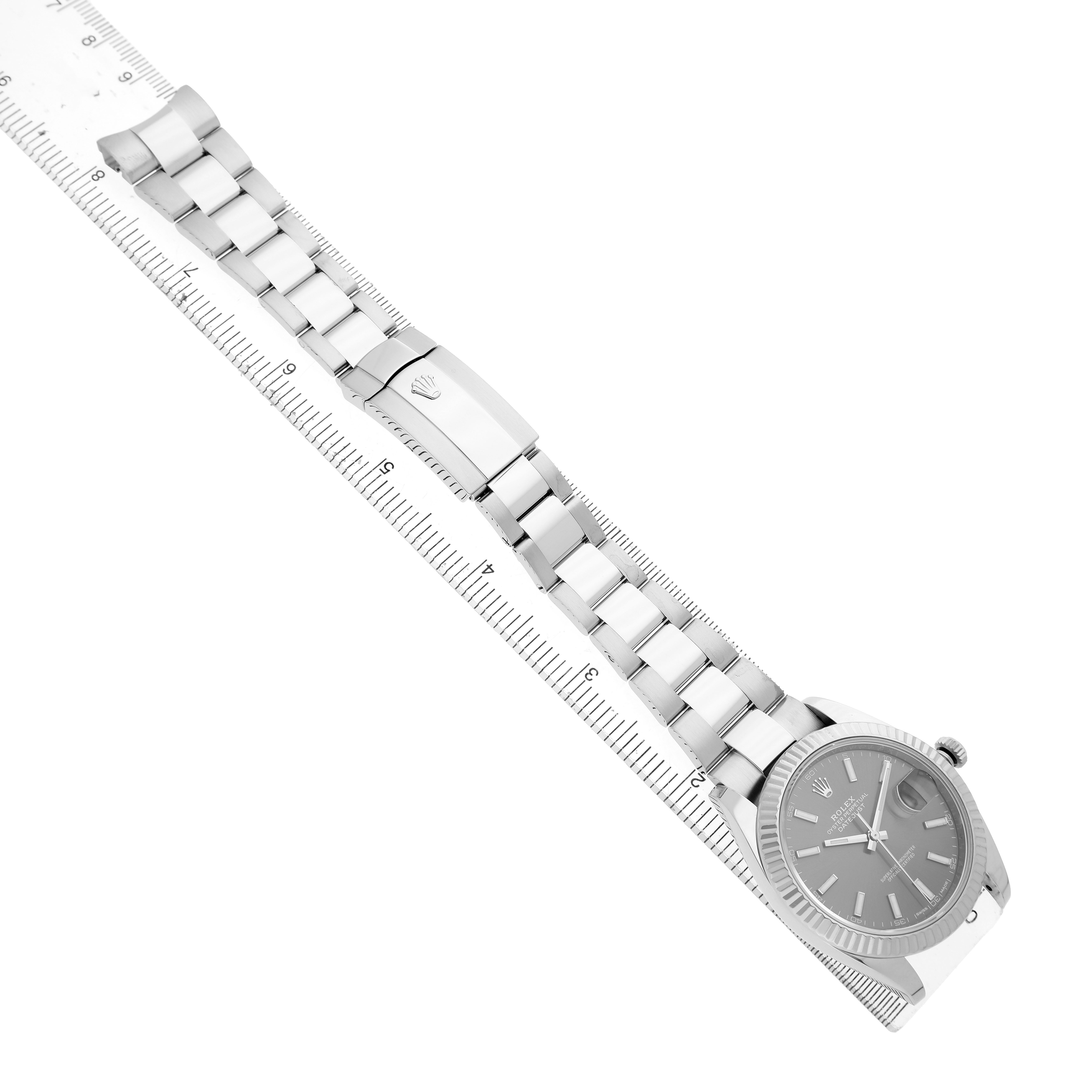 The Rolex Datejust 41 126334 Men's Stainless Steel Grey Dial watch is shown from a top-down angle, displaying the full bracelet and clasp, alongside a ruler.