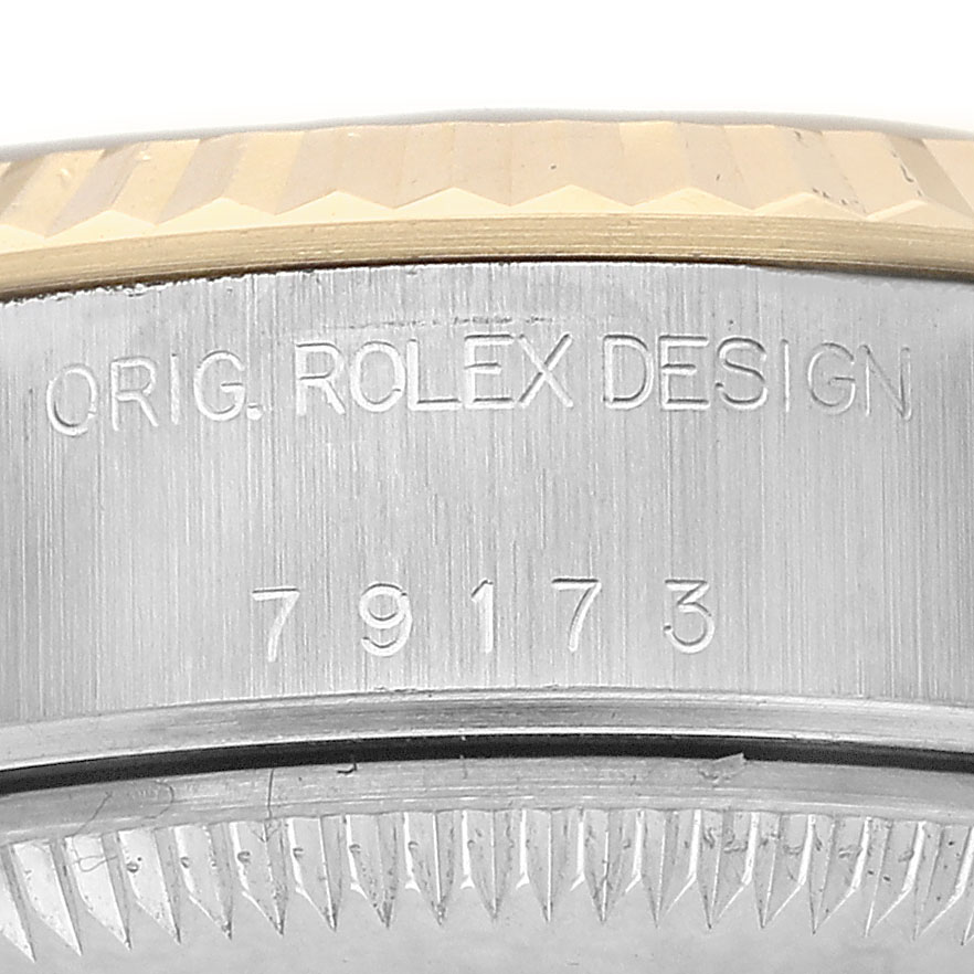 The image shows a close-up of the serial number and "Orig. Rolex Design" engraving on a Rolex Datejust 79173 Women's Stainless Steel Blue Dial watch bezel.