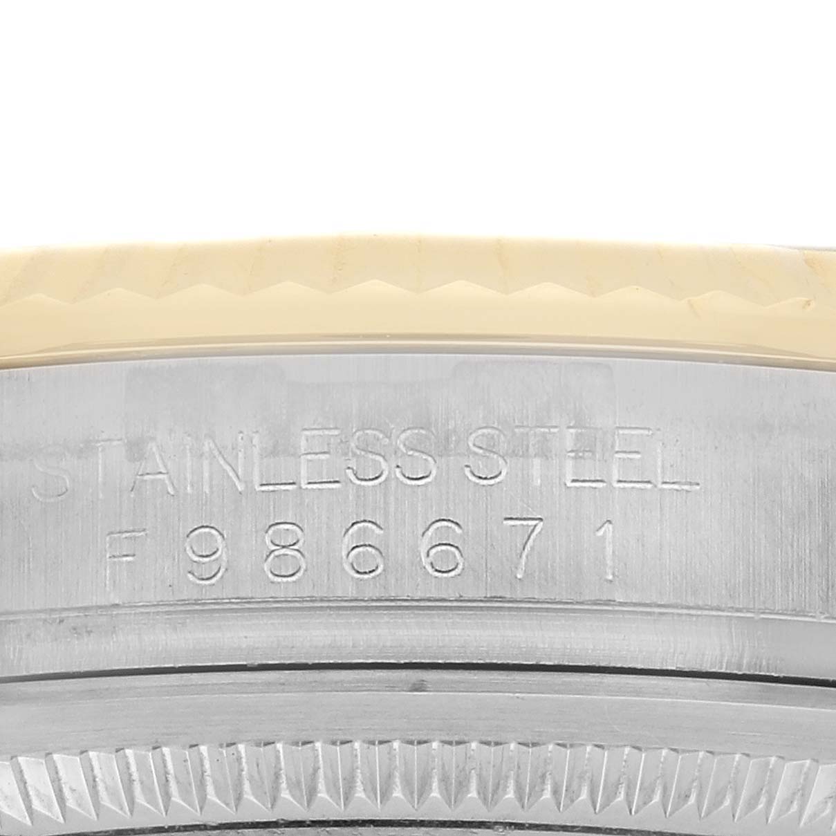 The image shows a close-up of the steel case detail with engravings and part of the bezel of the Rolex Datejust 116233 Men's Steel and Gold (two tone) Blue Dial model.