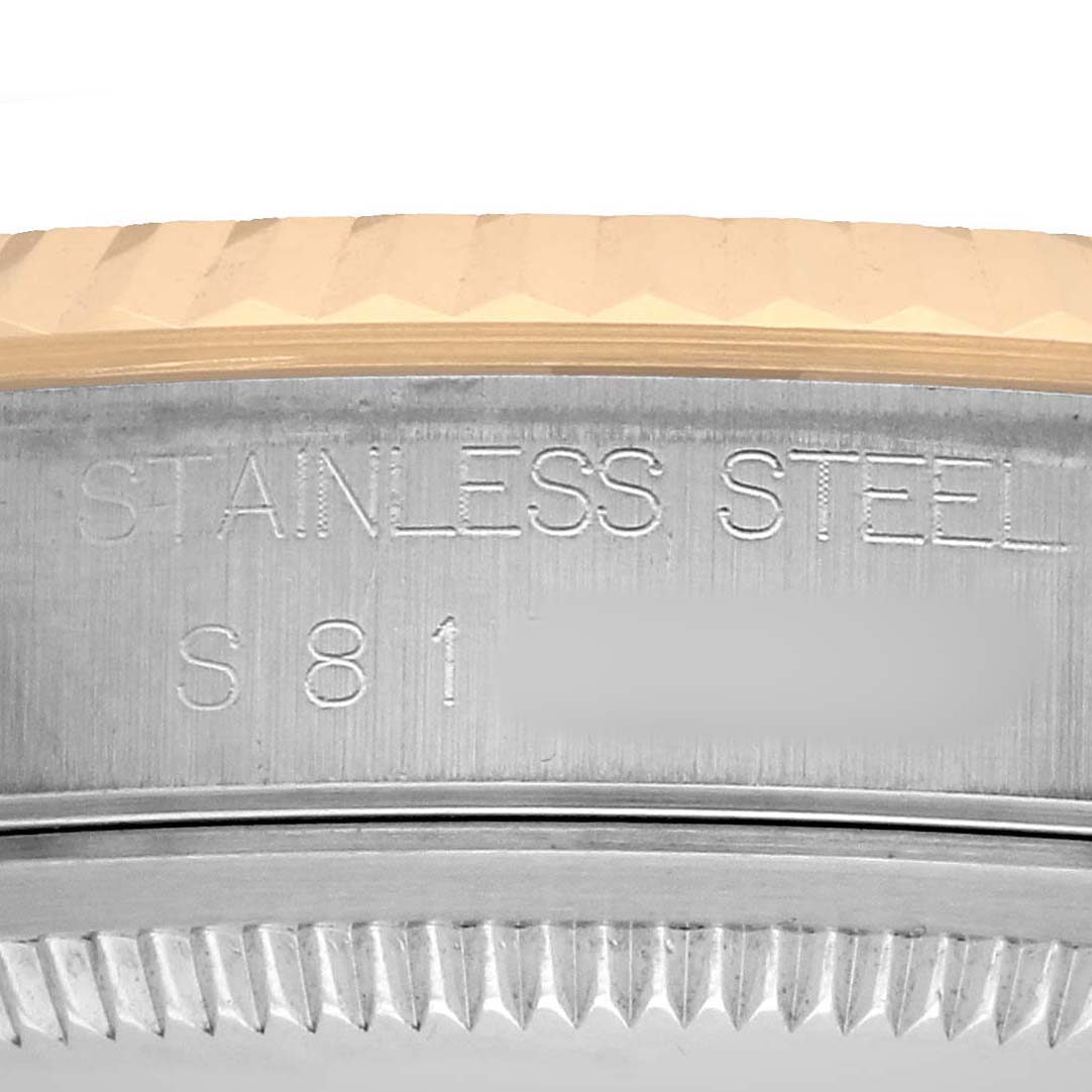 The image shows a close-up of the side engraving and fluted bezel of a Rolex Datejust 16233 Men's Steel and Gold (two tone) White Dial watch.