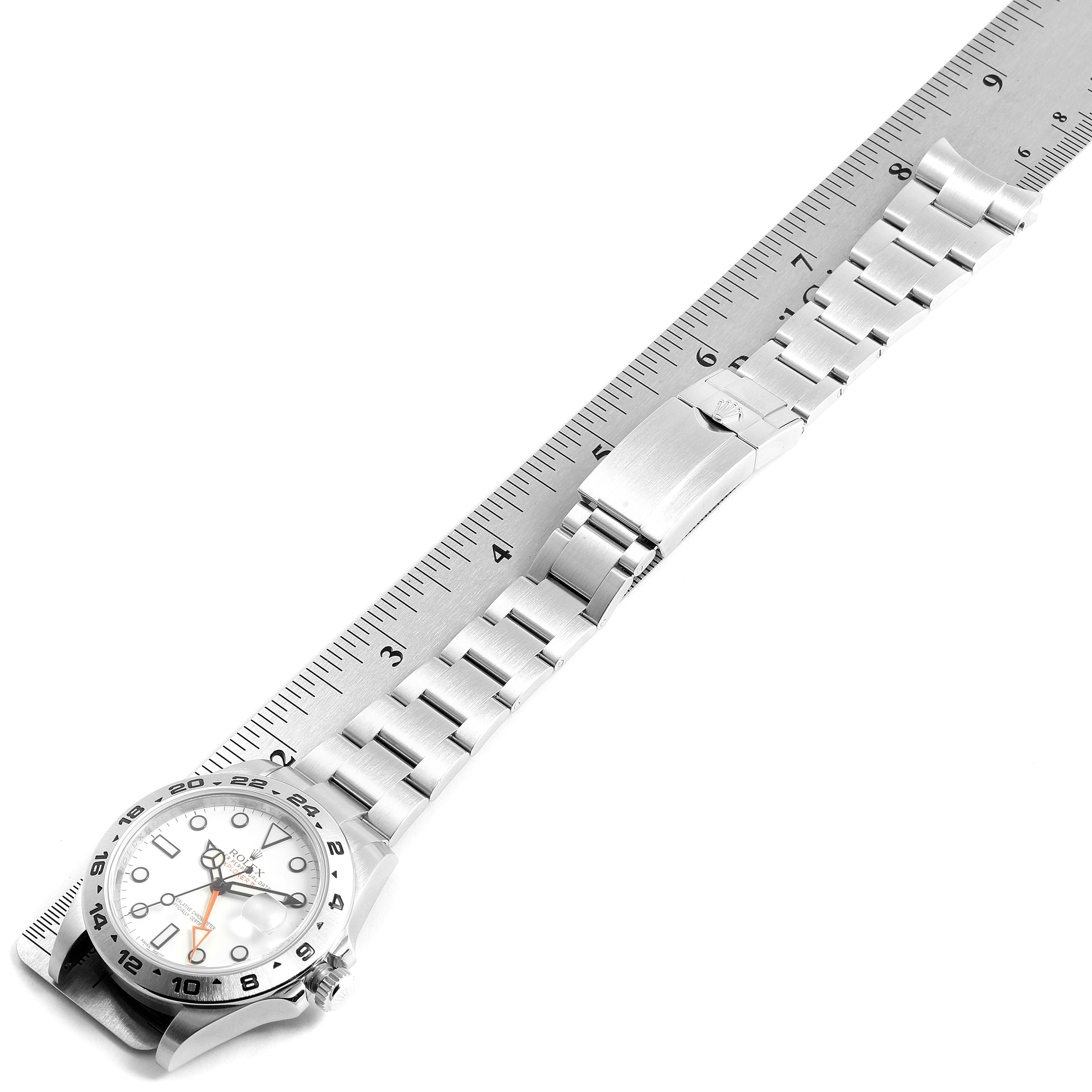 The image shows a Rolex Explorer 216570 Men
s Stainless Steel White Dial 216570 Men
s Stainless Steel White Dial watch laid flat with a ruler, displaying the bracelet and face at an angle.