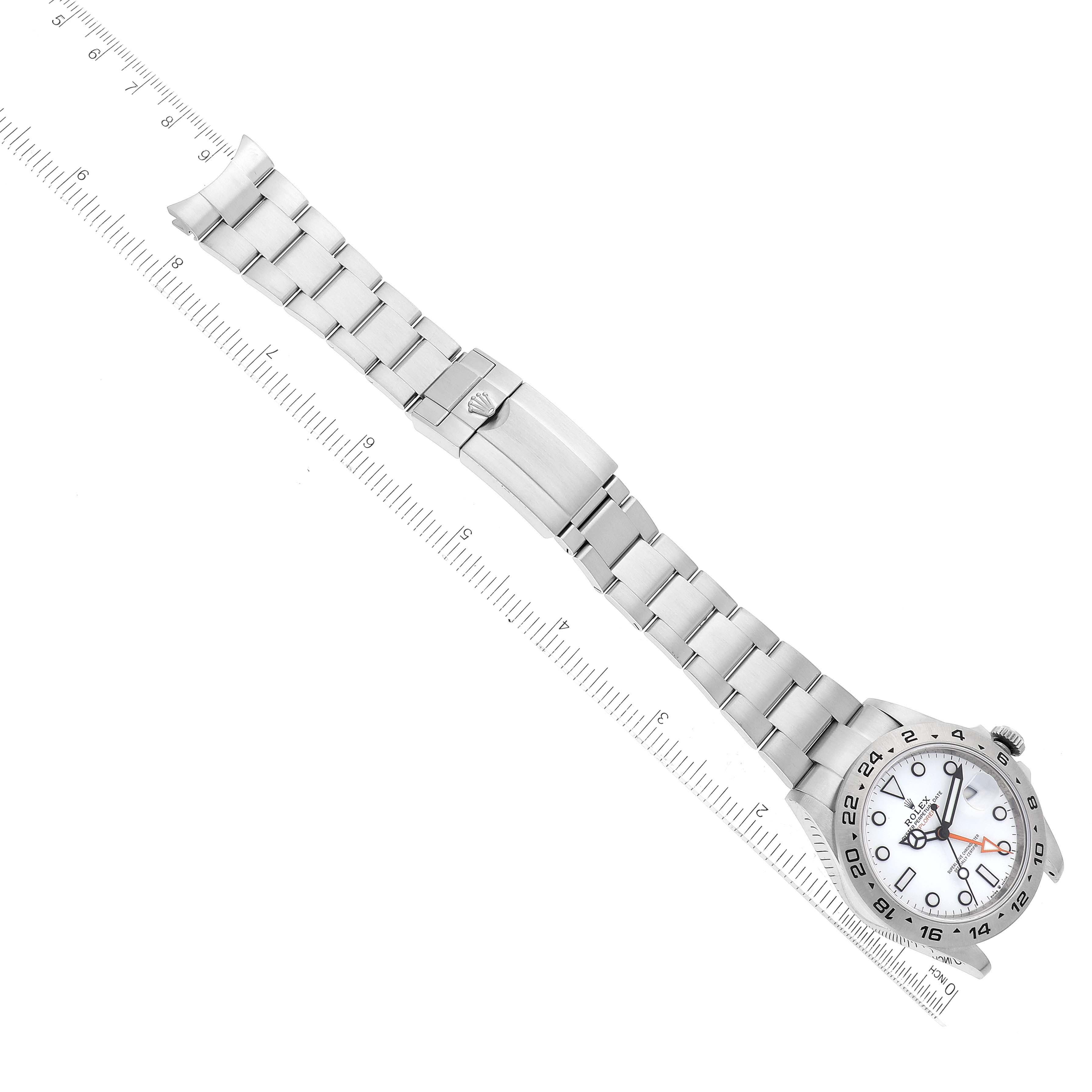 The image shows a top-down view of a Rolex Explorer 226570 Men
s Stainless Steel White Dial 226570 Men
s Stainless Steel White Dial watch, displaying its bracelet, clasp, and part of the face with indicators.