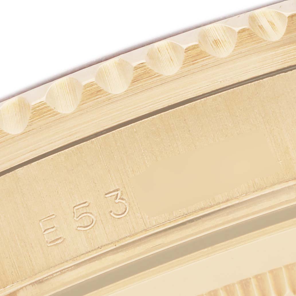 The image shows a close-up of the edge and engravings on the bezel of the Rolex GMT-Master 16718 Men's Yellow Gold Brown Dial watch.