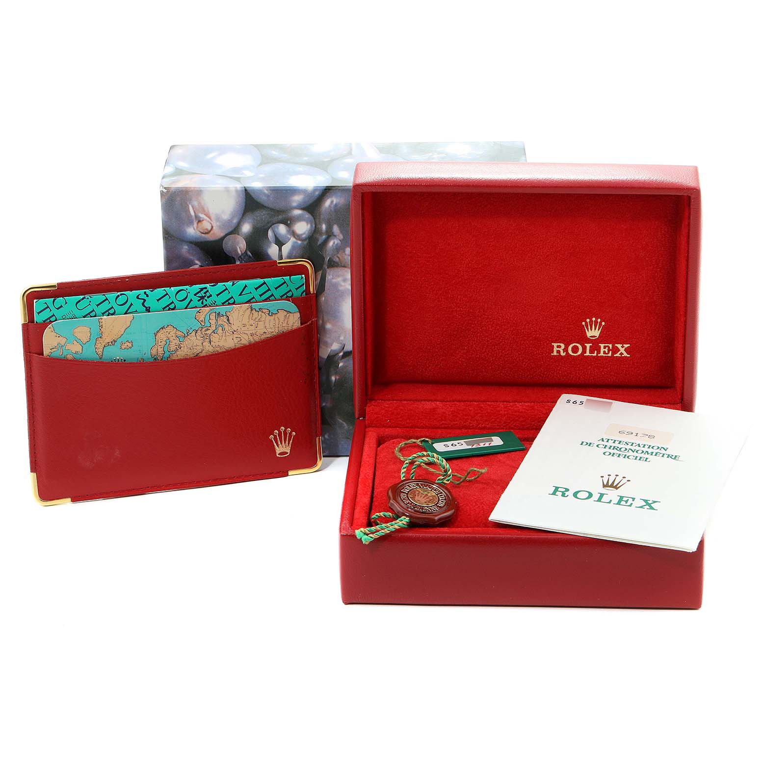 This image shows the accessories for a Rolex President 69178 Women
s Yellow Gold Blue Dial 69178 Women
s Yellow Gold Blue Dial model, including the red box, booklet, and cardholder.