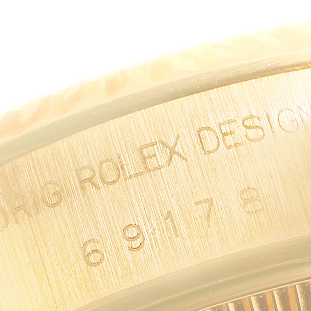 The image shows a close-up of the case side of a Rolex President 69178 Women
s Yellow Gold Blue Dial 69178 Women
s Yellow Gold Blue Dial model, highlighting its engraved details.