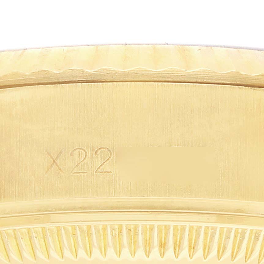 The image shows a close-up of the fluted bezel of a Rolex President 69178 Women's Yellow Gold Champagne Dial watch.