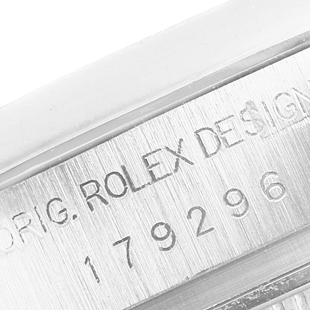 The image shows a close-up of the engraved serial number and "Rolex Design" text on the President model by Rolex.