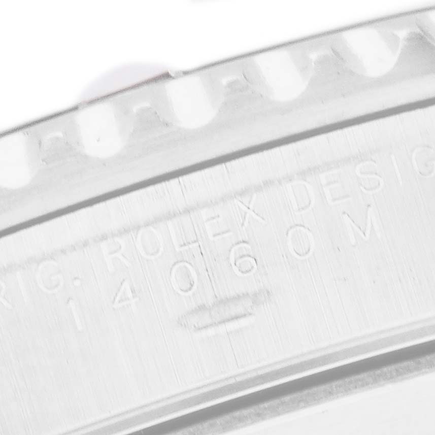 The image shows a close-up of the case engraving on a Rolex Submariner 14060 Men's Stainless Steel Black Dial, featuring model details.